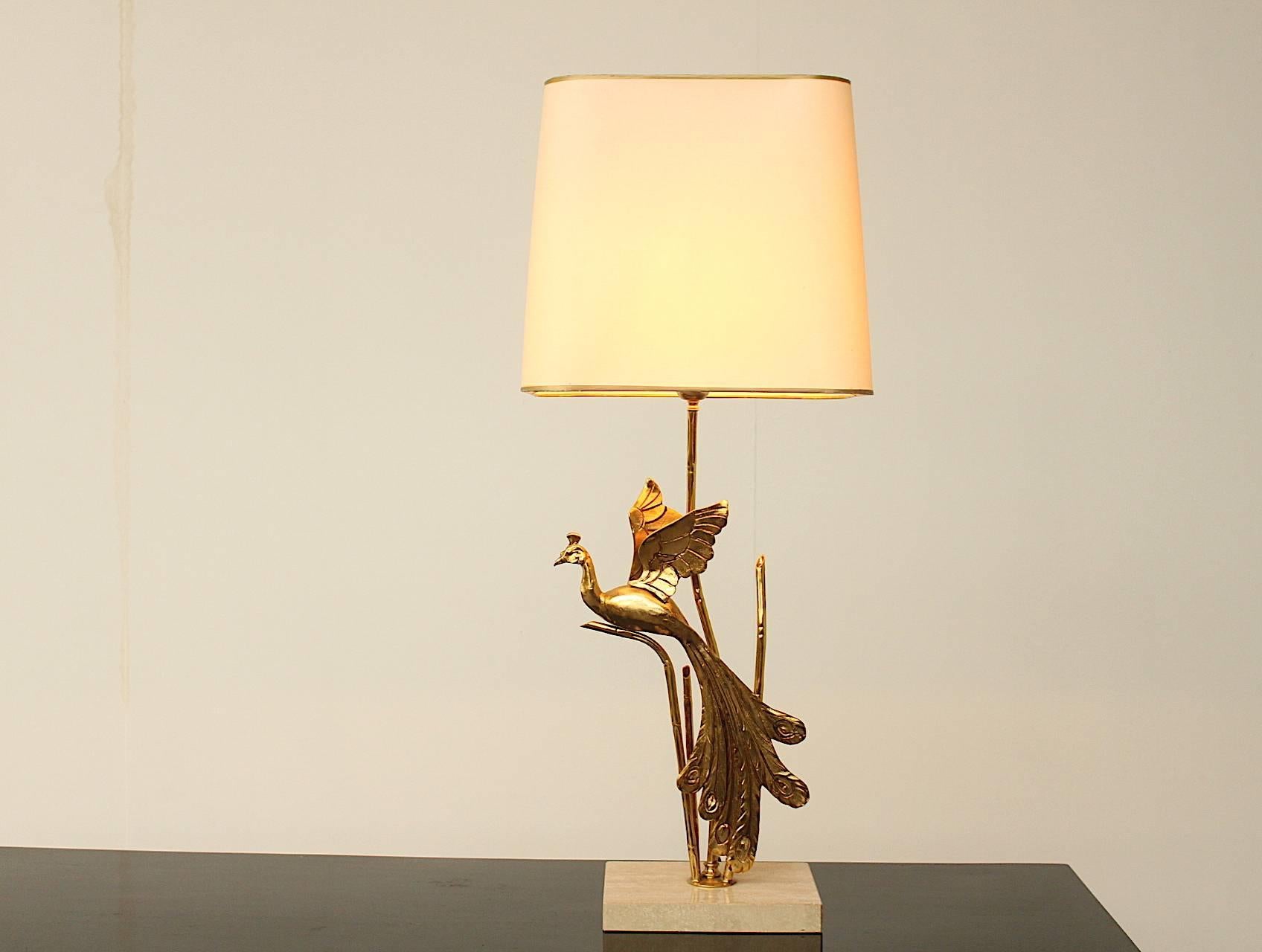 Impressive large and very chic table or buffet lamp featuring a gilt metal peacock mounted on a travertine base. The shade is in perfect condition and the lights are wired for the US. Fully functional and to be placed and used straight away. To be
