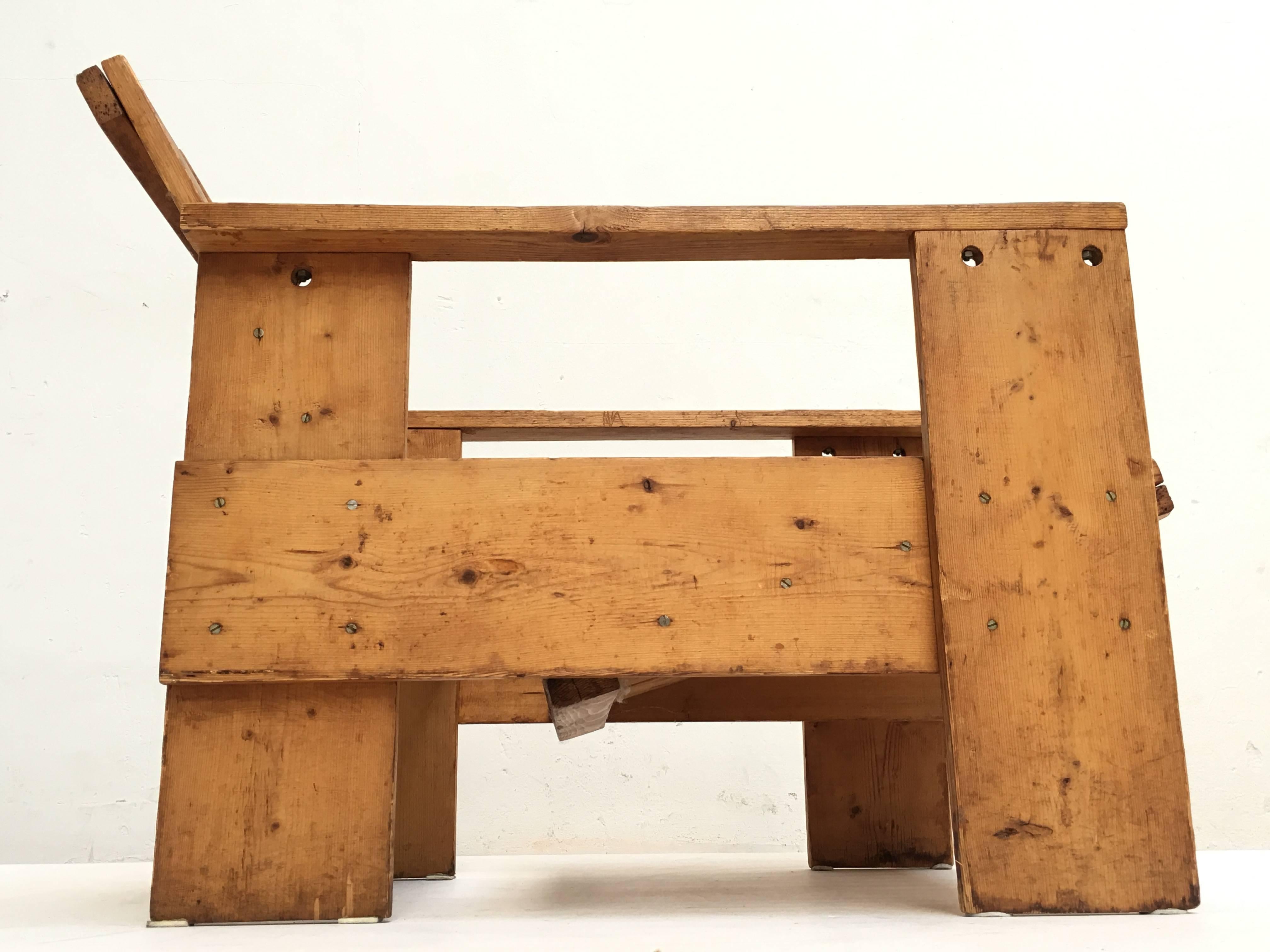 A pinewood crate chair produced, circa 1940s.

This chair is period authentic piece and has a few interesting features that Gerrit Rietveld also used on his zig zag chairs.
The armrests are connected by a nut and bold construction, by means of a