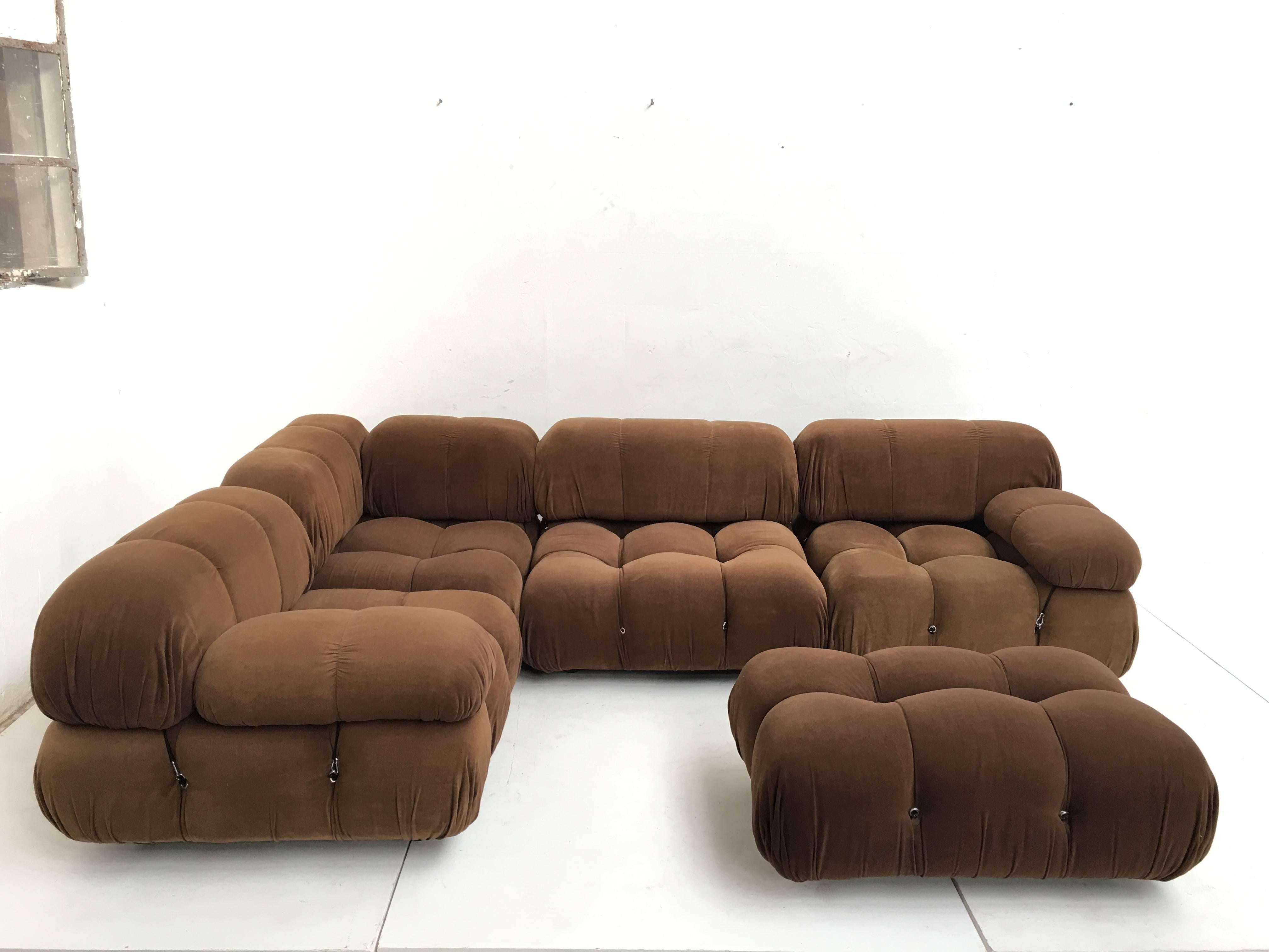 This early example comprising four large seating elements, an ottoman, six large back rests, one rare small backrest and two armrest retains its original brown fabric upholstery and original labels to the underside of the seat elements.

The rare
