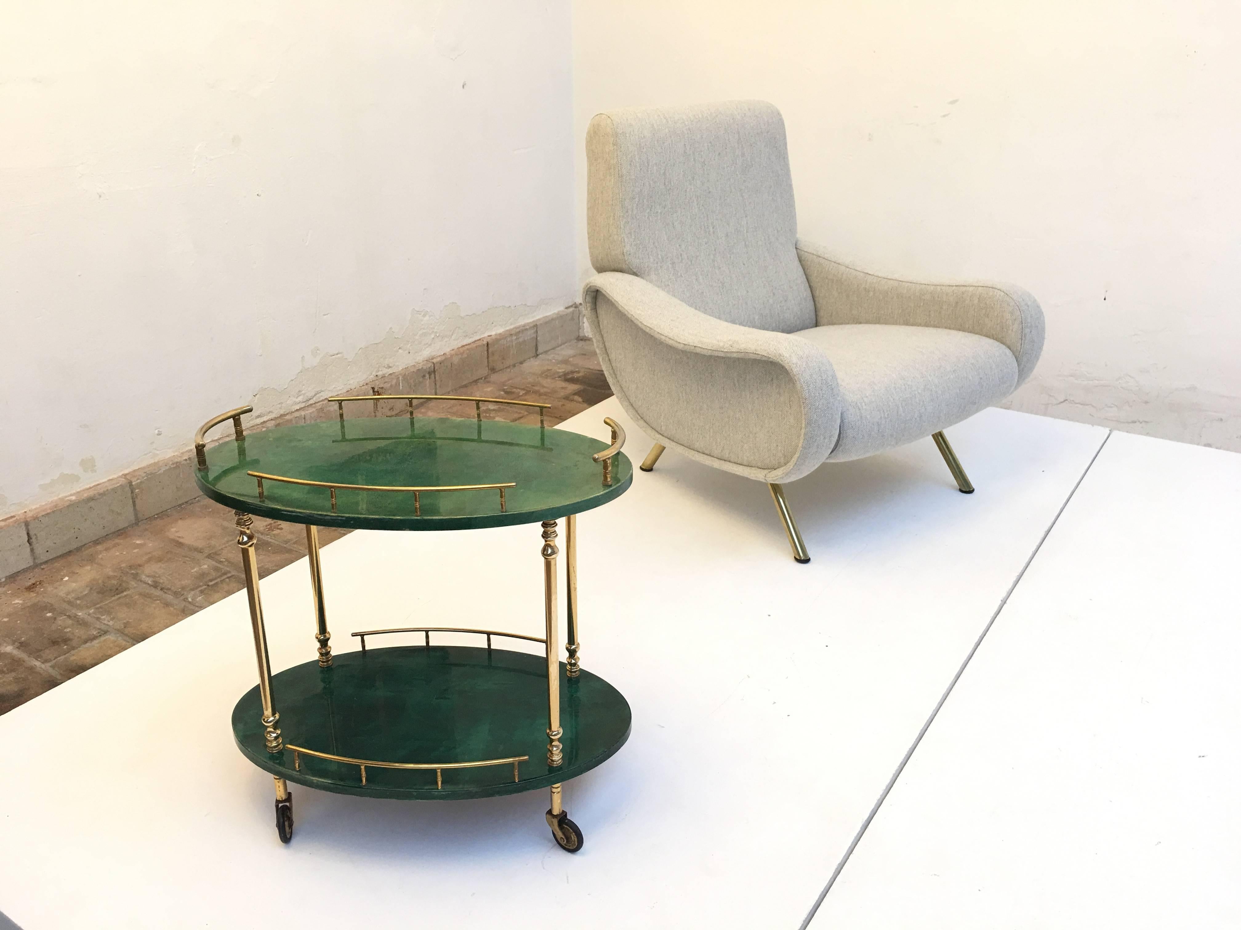 Top quality Italian chique by designer and entrepreneur Aldo Tura produced in Milan in the 1960s

This diminutive mobile drink cart or side table is made of brass and lacquered green dyed goatskin on wood

It is marked with the Aldo Tura label