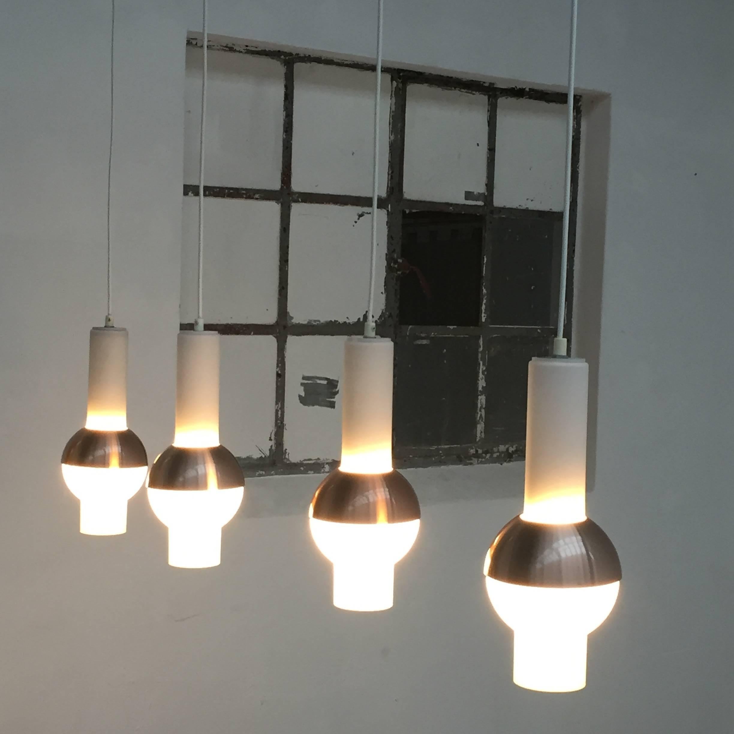 Set of 4 glass and brass anodised aluminium pendants by Raak Lighting Architecture Amsterdam first listed in their catalogue in 1966 and only in production for 3 years

The pendants are clearly influenced by the Space Race from the late 1960's and