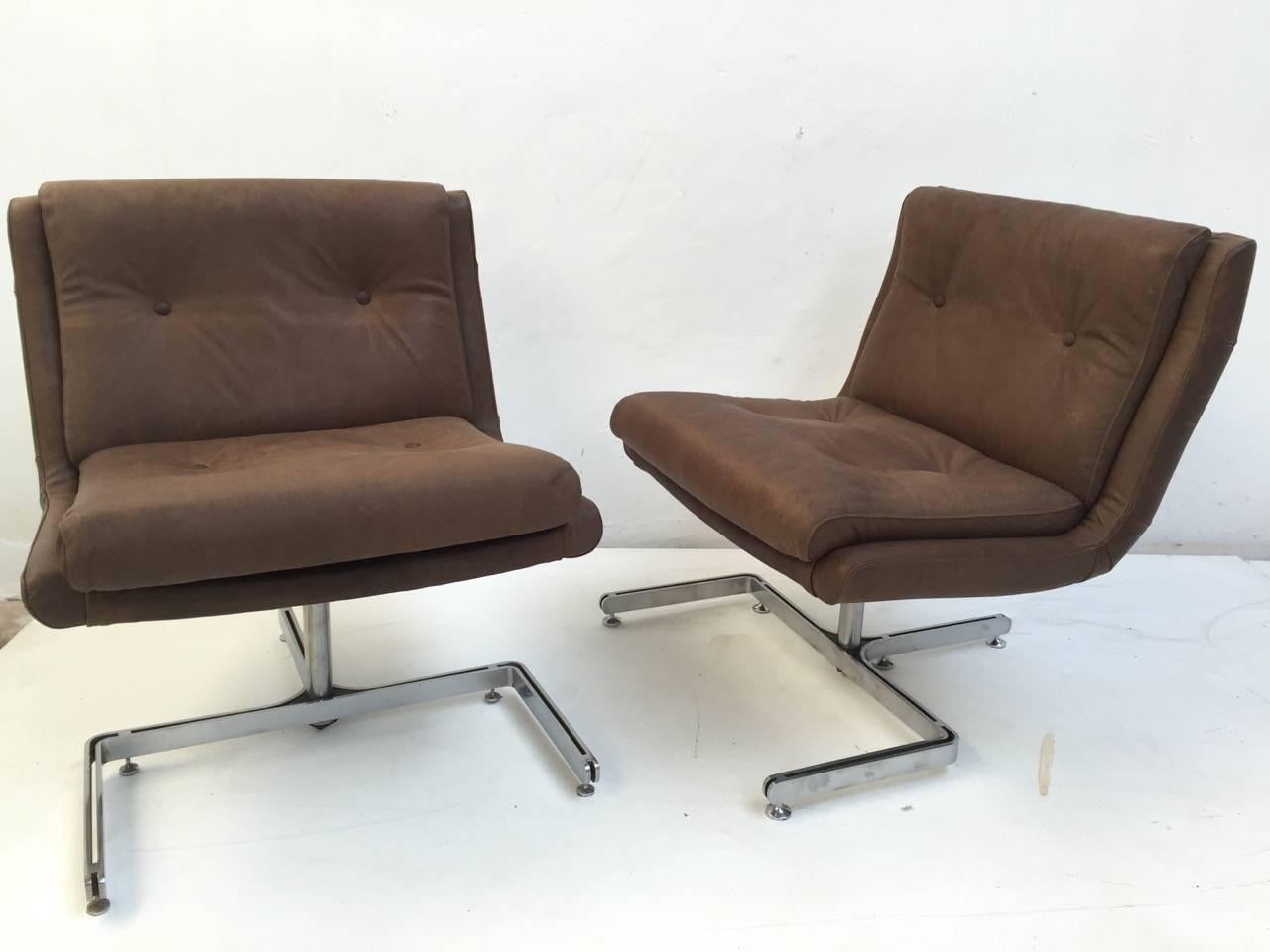 Lovely pair of leather lounge chairs by French designer Raphael. These chairs have been freshly reupholstered in brown leather, with a snake skin impression, specially commissioned by us. The chairs have also had their foam and expensive, authentic