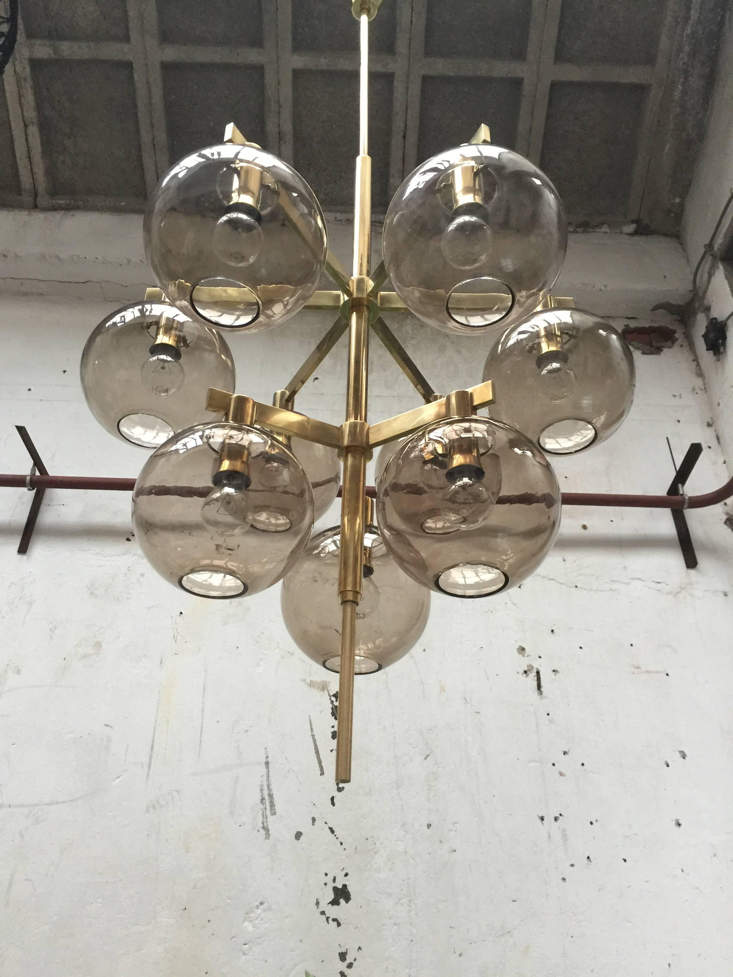 Top Swedish quality chandelier by Hans-Agne Jakobsson Markaryd in brass with nine smoked handblown glass globes.

Hans Agne Jacobson founded his own company in 1951 and produced high quality Scandinavian lighting during his career.

We have two