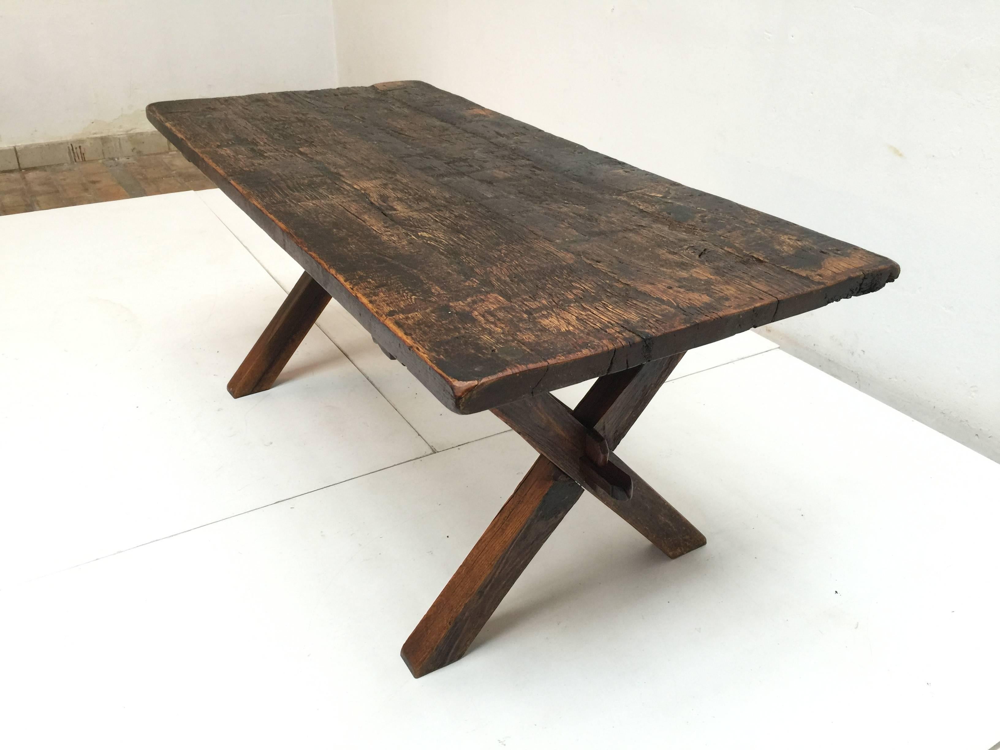 Brutalist looking French rustic stained oak dining table. 

The raw finished solid stained oak has a beautiful aged and patinated look that is reminiscent to the works of French designer Pierre Chapo.

