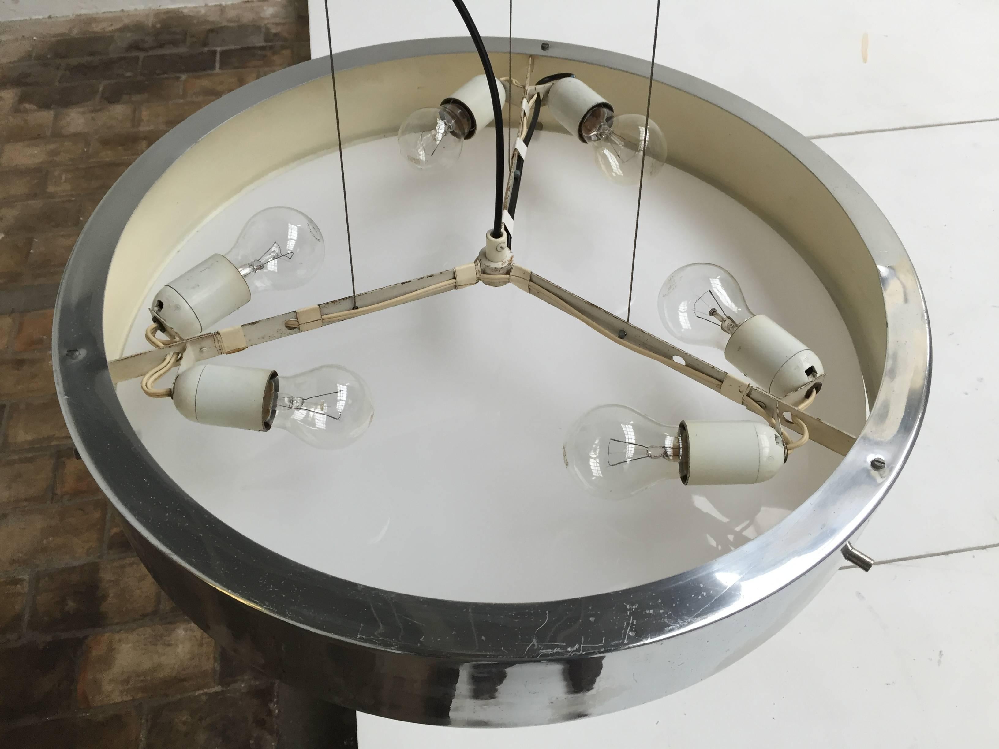 Beautiful minimal architectural pendant by the founder of Stilnovo, Italian designer Bruno Gatta.

The lamp was found with all the original parts and polished aluminium exterior shade with original milk glass diffuser but was failing the metal