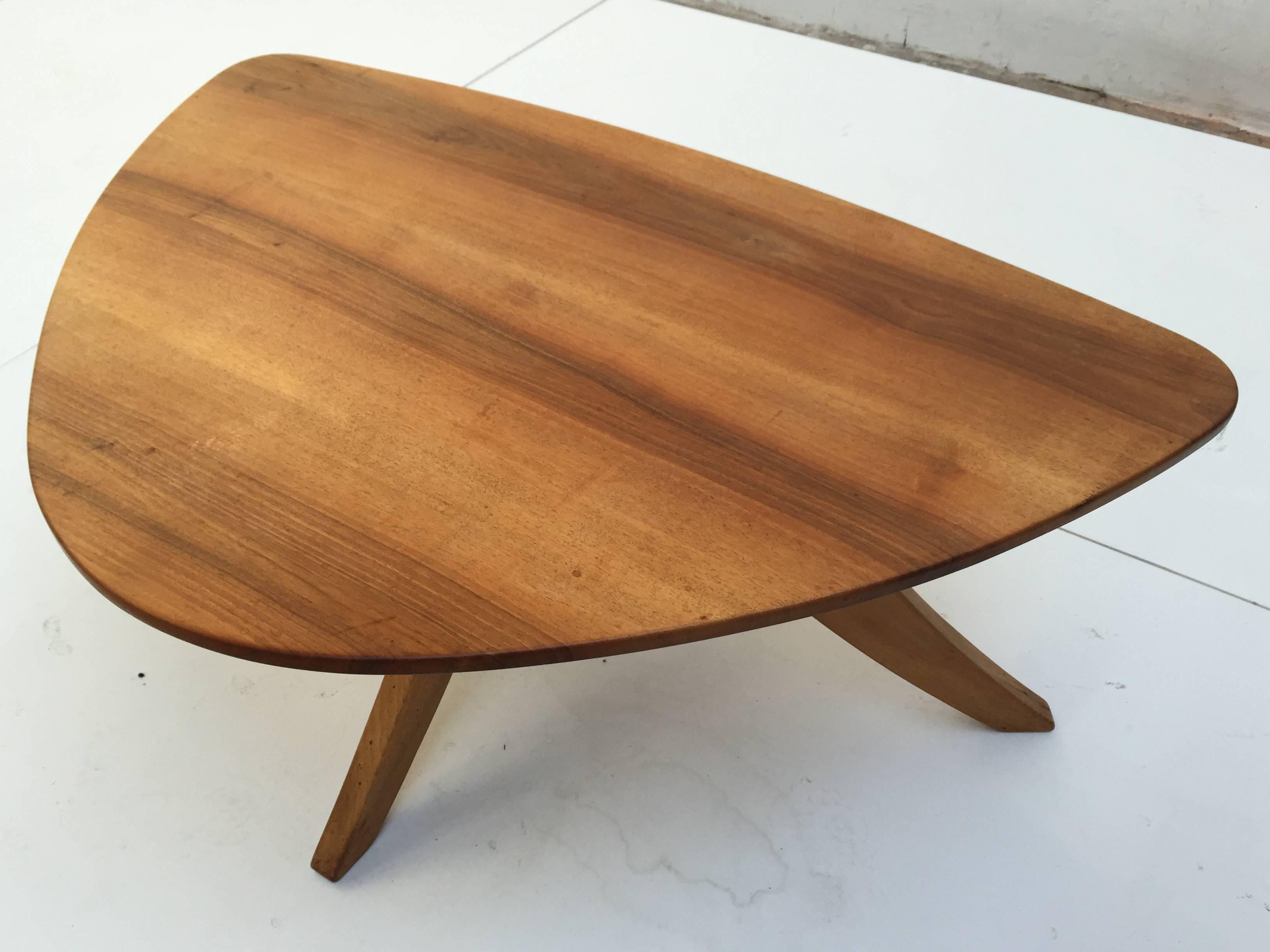 Beautiful 1950s triangle shaped two-tier coffee table in solid walnut designer is unknown but it would make a perfect match with the organic designs by Vladimir Kagan. The table is brand marked to the underside with cool and of high quality