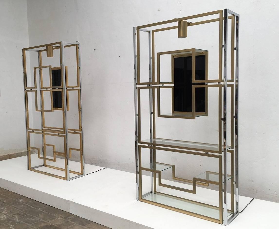 Supremely elegant pair of illuminated vitrine or étagère by Kim Moltzer with a beautiful sculptural geometric form, finished in brass and chrome, which support eight glass display shelves and a further central display niche that features a