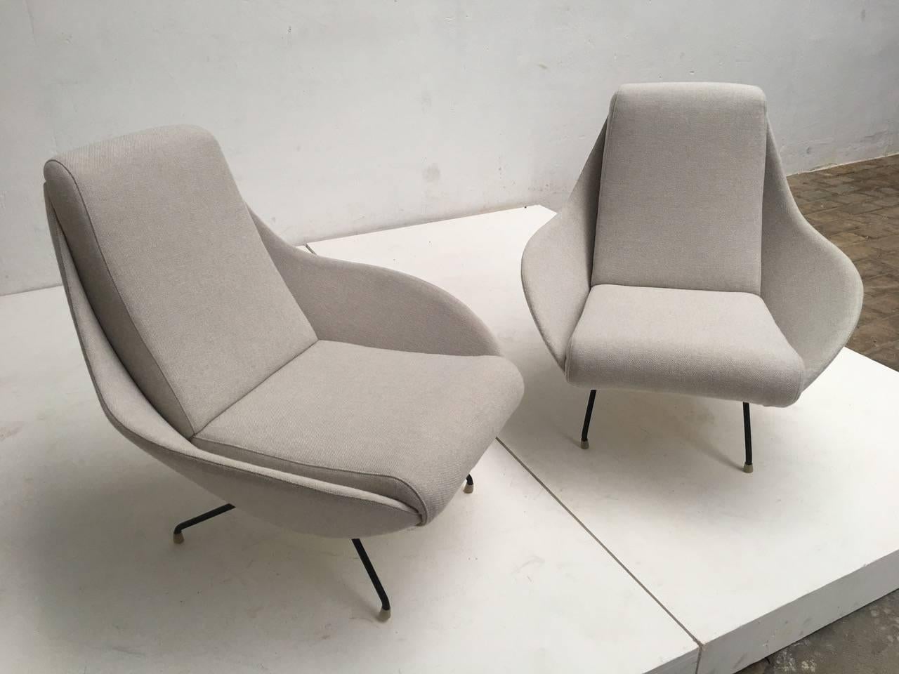 Pair of exquisite sculptural form Italian lounge chairs from the early-mid-1950s period featuring dramatic flowing eliptical 'mantis' form wings with a subtle sculptural double curvature which envelope you and form an integral lateral and arm
