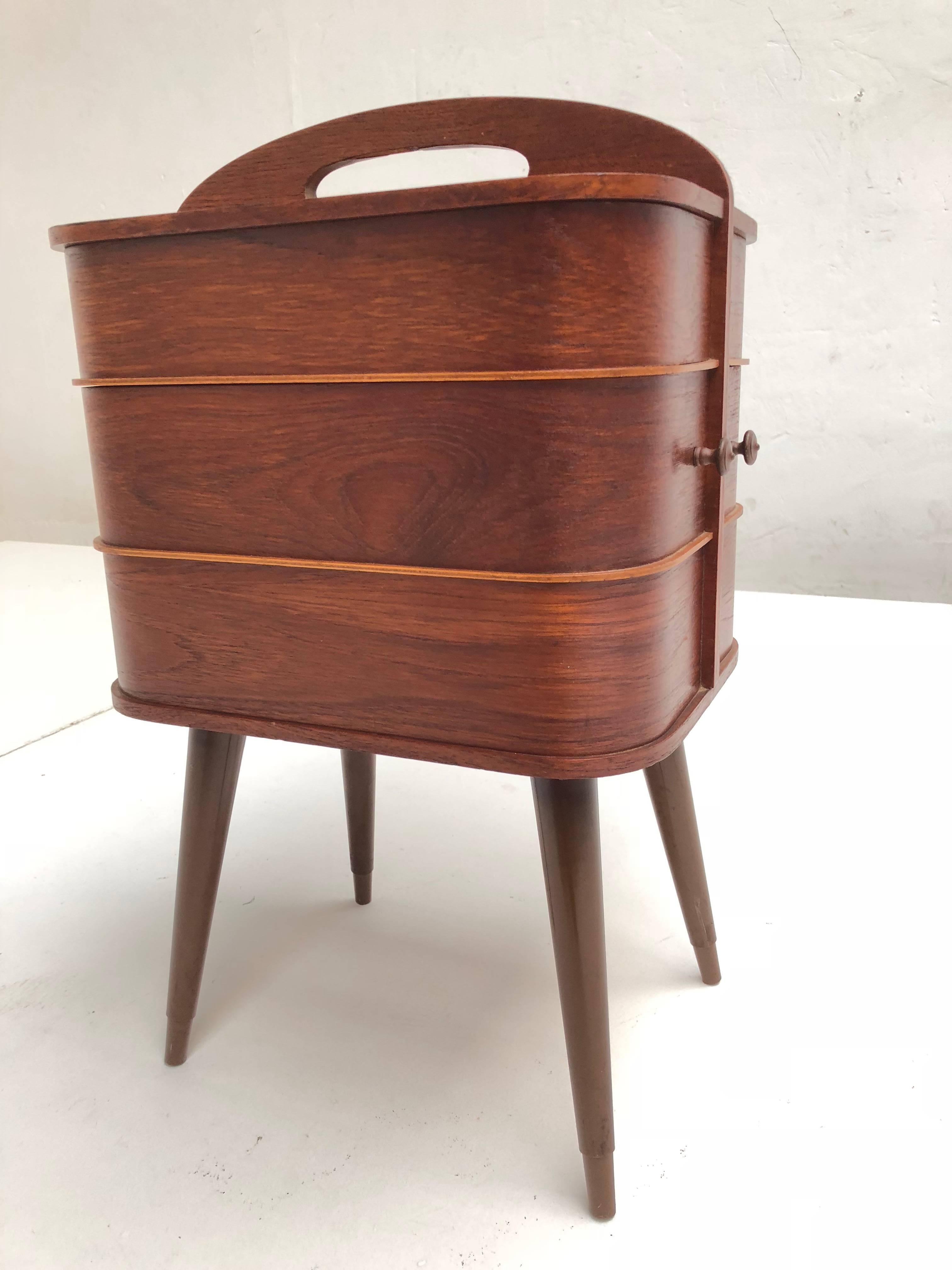 Danish Mid-Century Modern plywood sewing box with integrated handle and revolving drawers

This Teak finished plywood sewing box was imported and distributed in The Netherlands by UMS Pastoe that sold design by Cees Braakman, Arne Jacobsen and