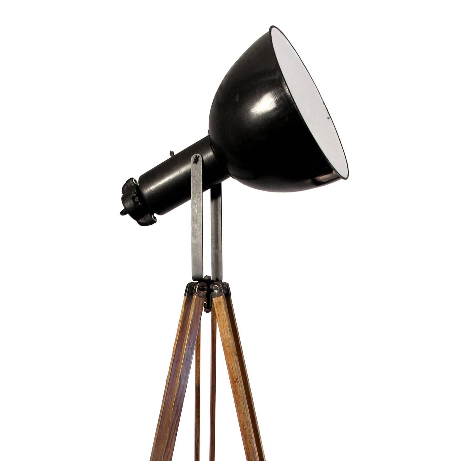 Vintage Industrial spotlight on wooden tripod. 
Adjustable height and angle. Black enamel spot with white interior. Diameter 42 cm. Weight 13.0 kg / 28.7 lb. Total height as shown in picture: 195 cm. 

All lamps have been made suitable by