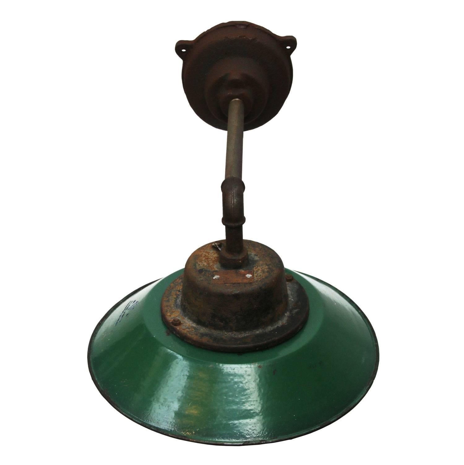 Green colored enamel Industrial wall light with white interior. Clear glass.
Diameter cast iron wall mount: 12 cm, three holes to secure,

weight: 5.5 kg / 12.1 lb

For use outdoors as well as indoors. 

All lamps have been made suitable by