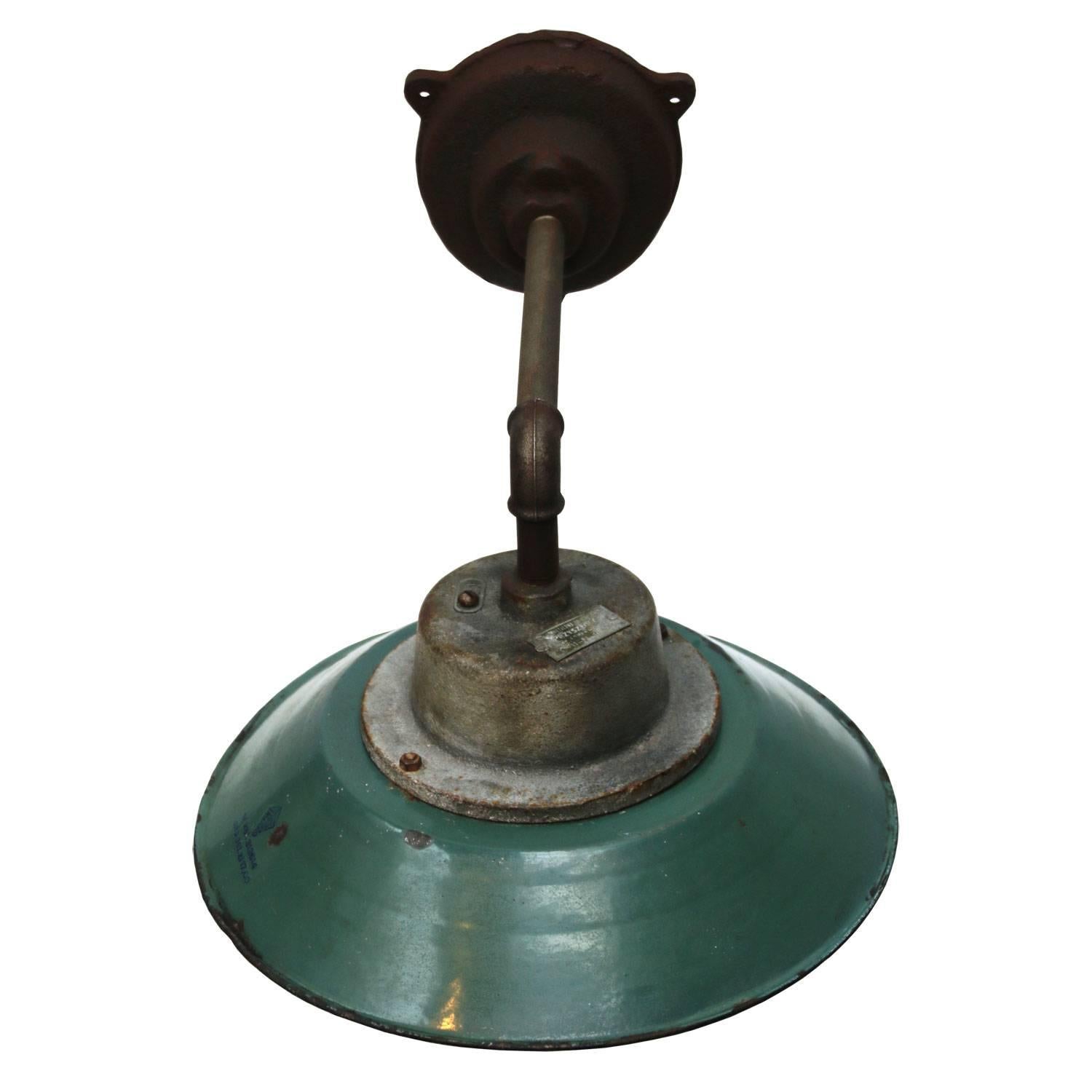 Petrol colored enamel industrial wall light with white interior. Clear glass.
Diameter cast iron wall mount: 12 cm, three holes to secure,

weight: 5.5 kg / 12.1 lb

For use outdoors as well as indoors. 

Priced per individual item. All lamps have