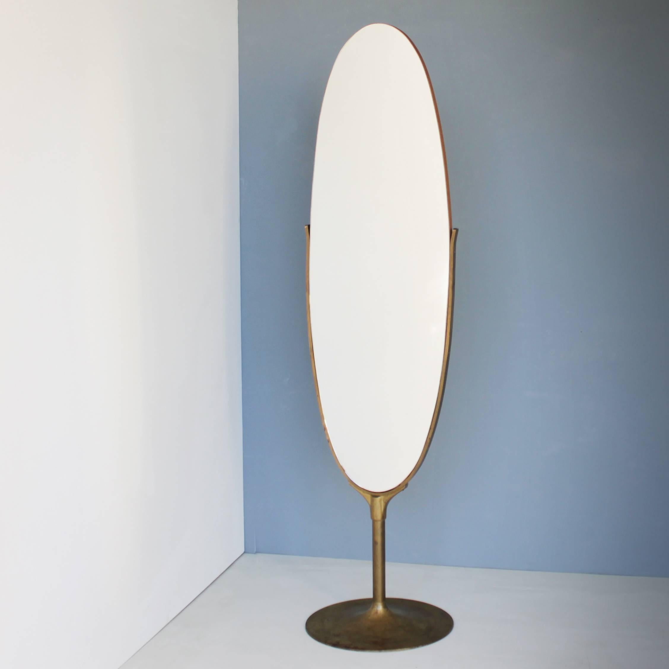 Large oval floor mirror with a brass base and an oak veneer backside. Scandinavia. Measures: Diameter brass base 18.5 in. (47 cm), total height 71.7 in. (182 cm), width of the mirror 18.5 in. (47 cm). New glass, beautiful condition.