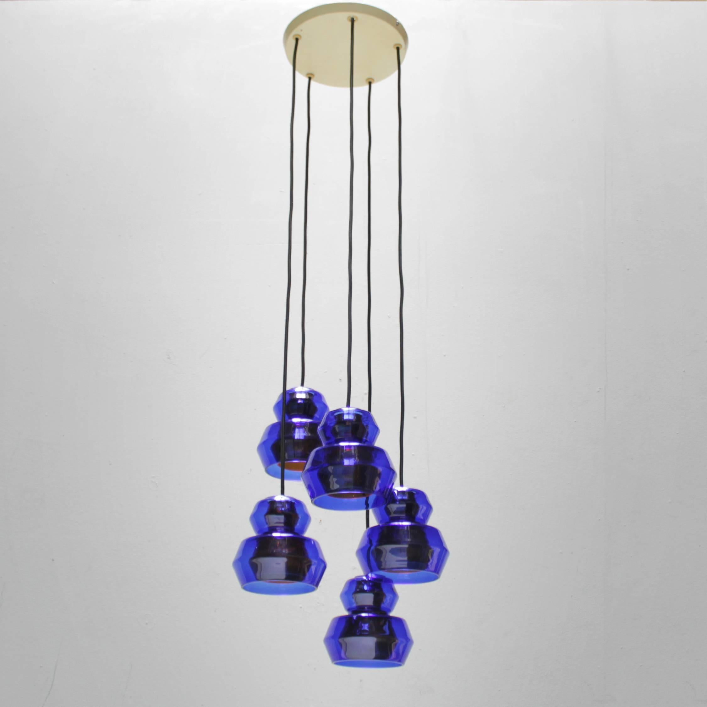 Five pendants, blue and orange glass by Vistosi Vetri Murano Italy. New textile wire, new sockets. 
Measurements: height from ceiling to drop: 43.3 in. (110 cm), diameter canopy: 8.6 in. (22 cm). Diameter of a lamp 5.5 inches (14 cm).
