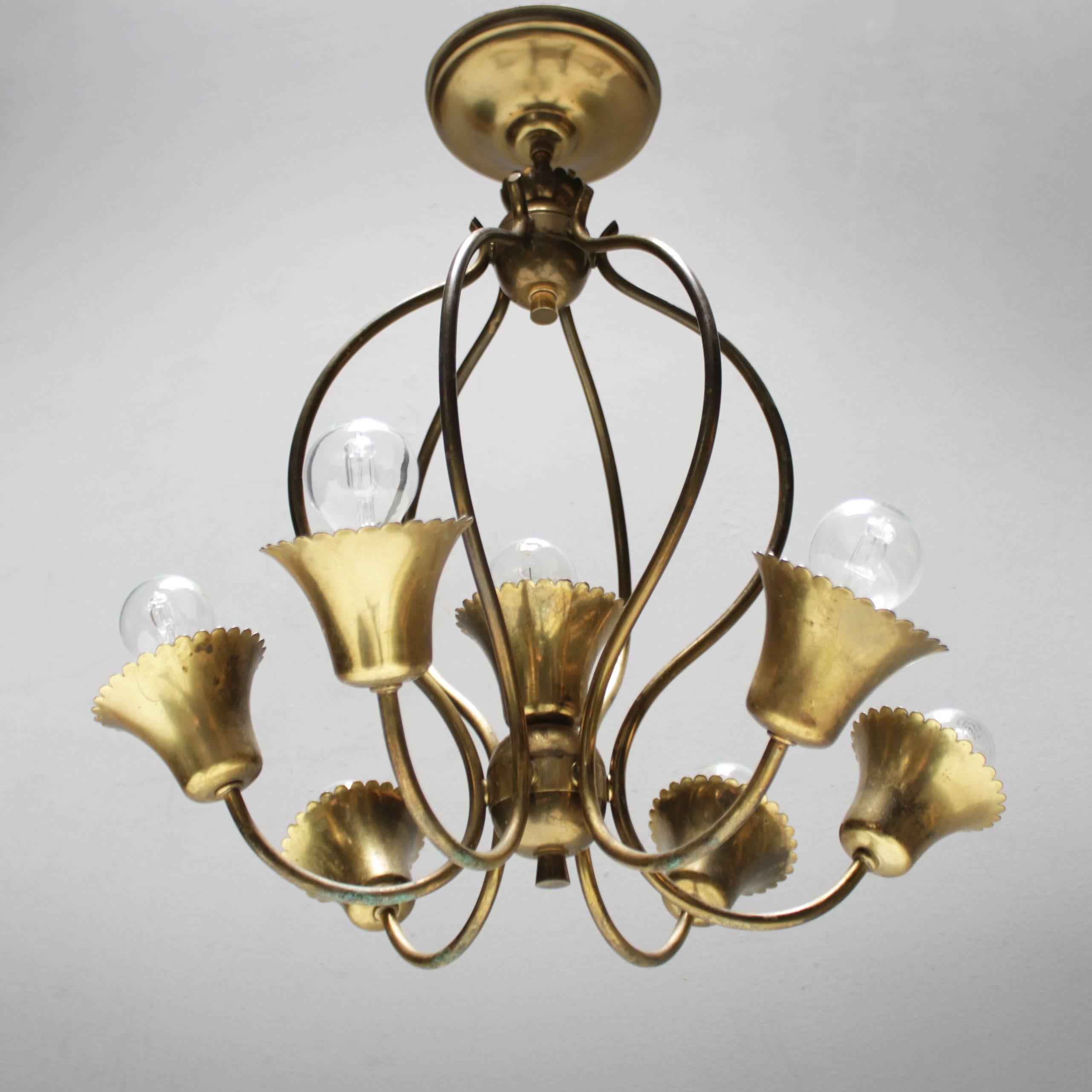 Nice mid size brass chandelier in the style of Gio Ponti, most likely produced by Arredoluce. The fixture holds 7 lamps: six small Edison screws and one with a regular Edison screw (mounted in the center).
The chandelier has recently been