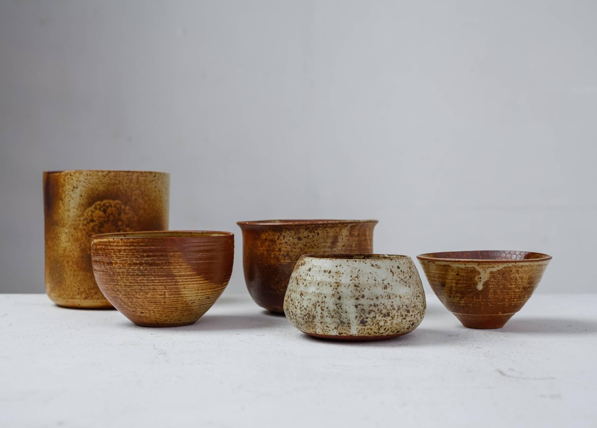 A set of five bowls with a brown and earth tone glaze finish, by French ceramist Franco Agnese. 
The lowest piece is 6.5 cm (2.5