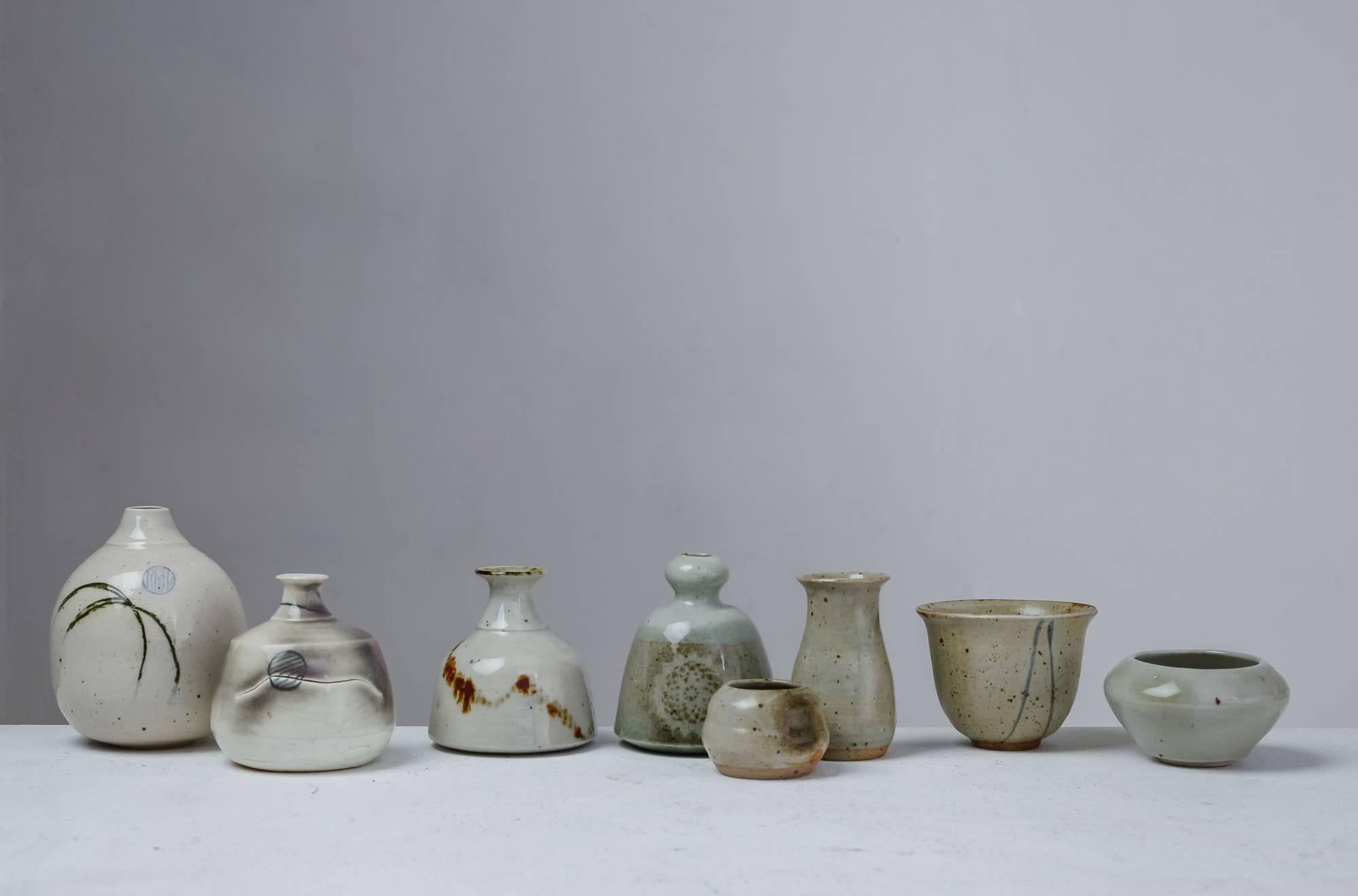 A set of eight vases and bowls with a mostly grey glaze finish, by French ceramist Franco Agnese. 
The lowest piece is 4.5 cm (1.8 inch) high and has a 6 cm (2.4 inch) diameter. The tallest vase is 13 cm (5.1 inch) high with a 10 cm (3.9 inch)
