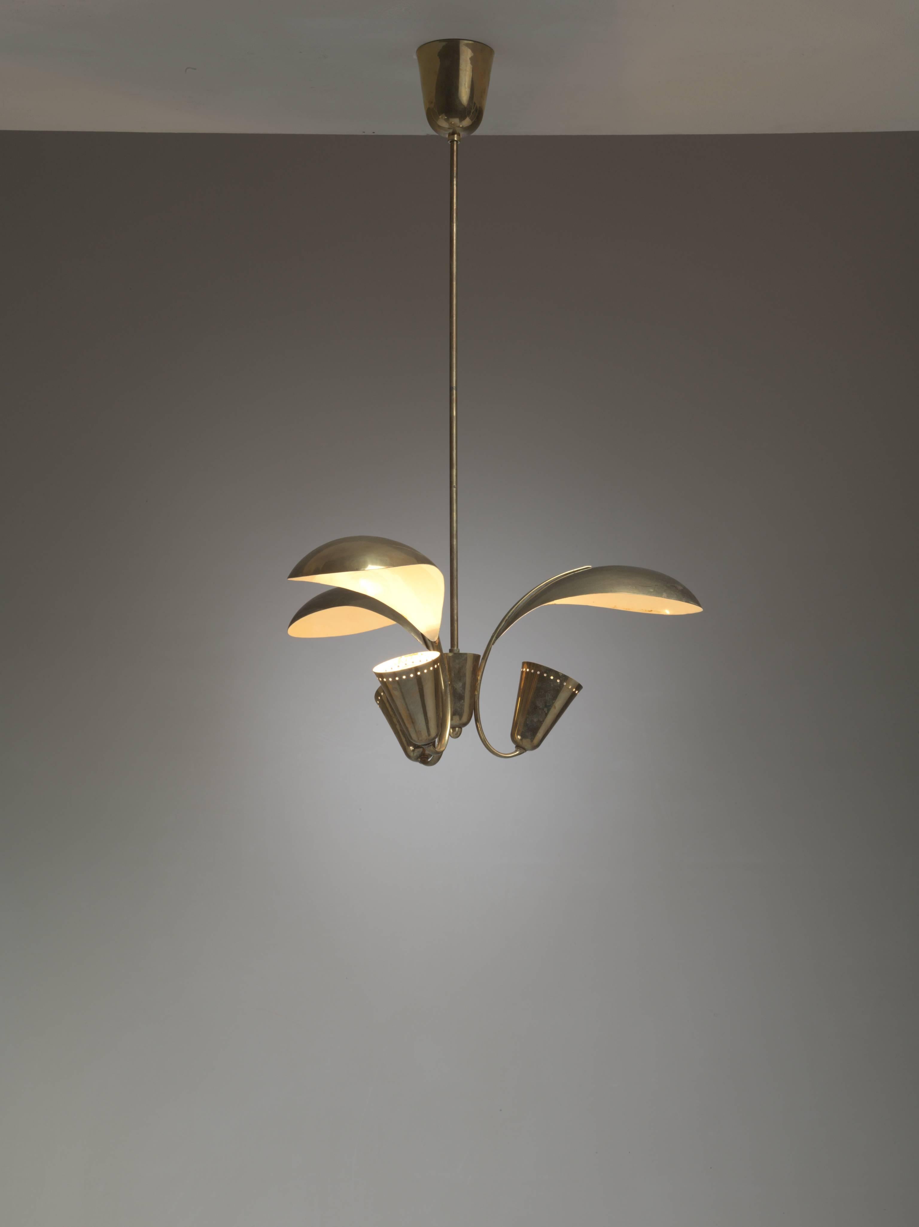 A three-armed brass Paavo Tynell chandelier for Idman. The lamp gives a beautiful indirect light, as a result of the large petal-shaped deflectors.