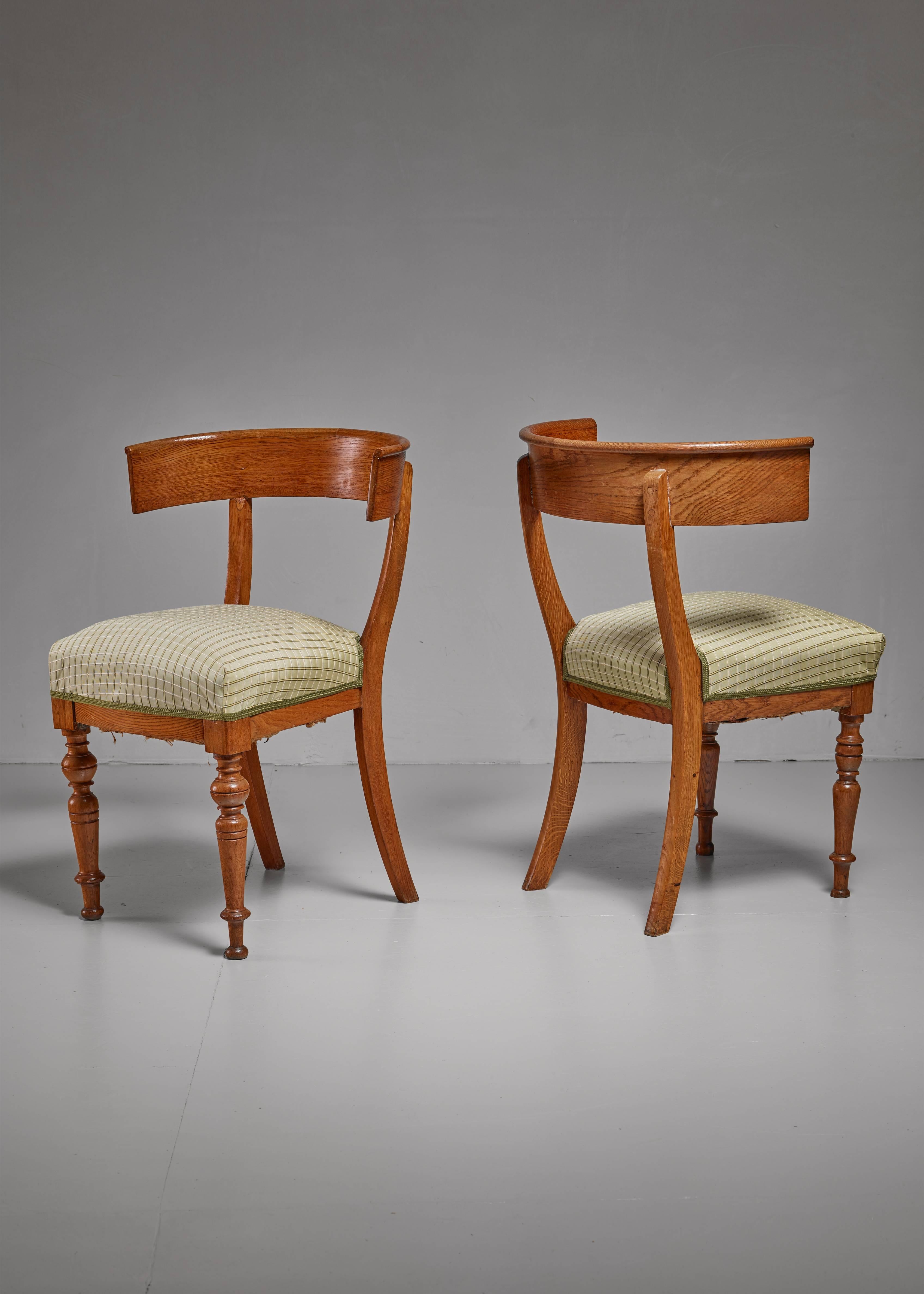 A pair of elegant Swedish oak Klismos chairs. The chairs have a curved backrest and sculpted legs in the front and sabre legs in the back.

* This set is curated for you by Bloomberry *