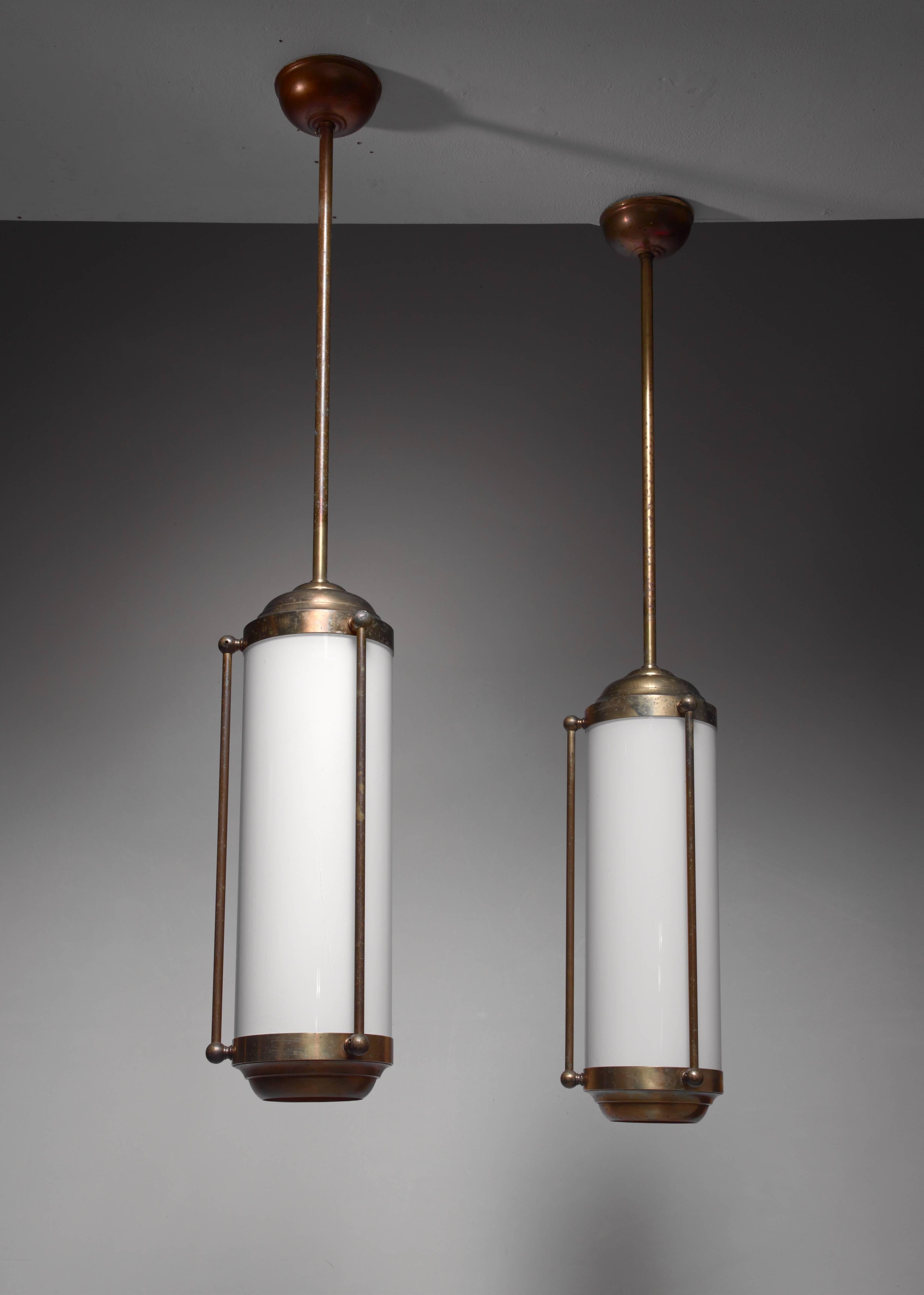 A cylindrical brass pendant lamp with a yellow plastic shade, hanging from a long brass stem.
We have a total of five of these lanterns available. The total drop can be adjusted. Wiring is checked and ready for immediate use.

The images show a
