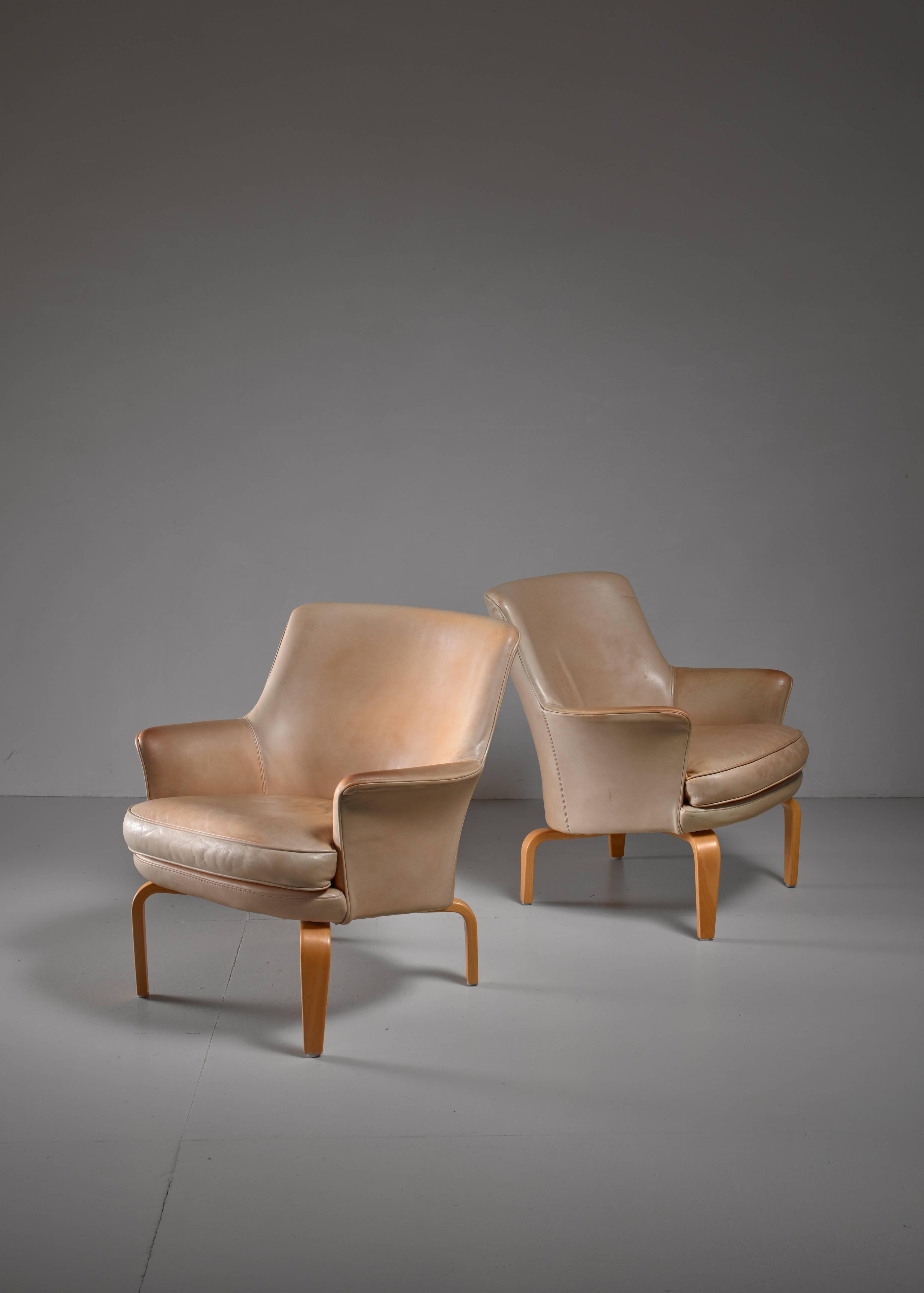 A pair of 'Pilot' beige leather lounge chairs on birch feet by Arne Norell for Norell Mobel AB.
Labeled by Norell and in a very good condition.
 