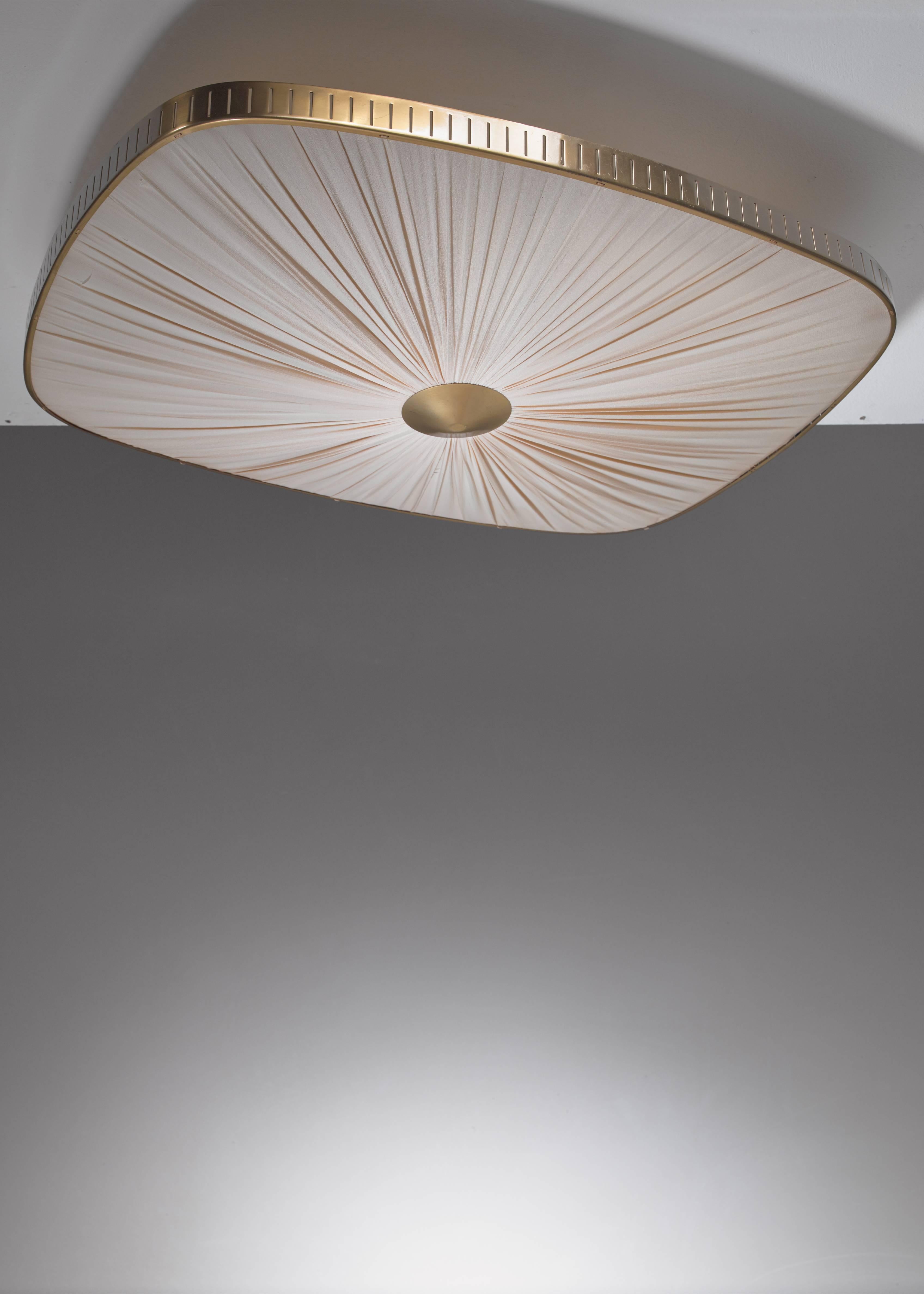 A 1940s Swedish flush mount ceiling lamp in the manner of Hans Bergström. It is made of a brass frame with perforations and a pleated Crêpe de Chine silk shade.
 