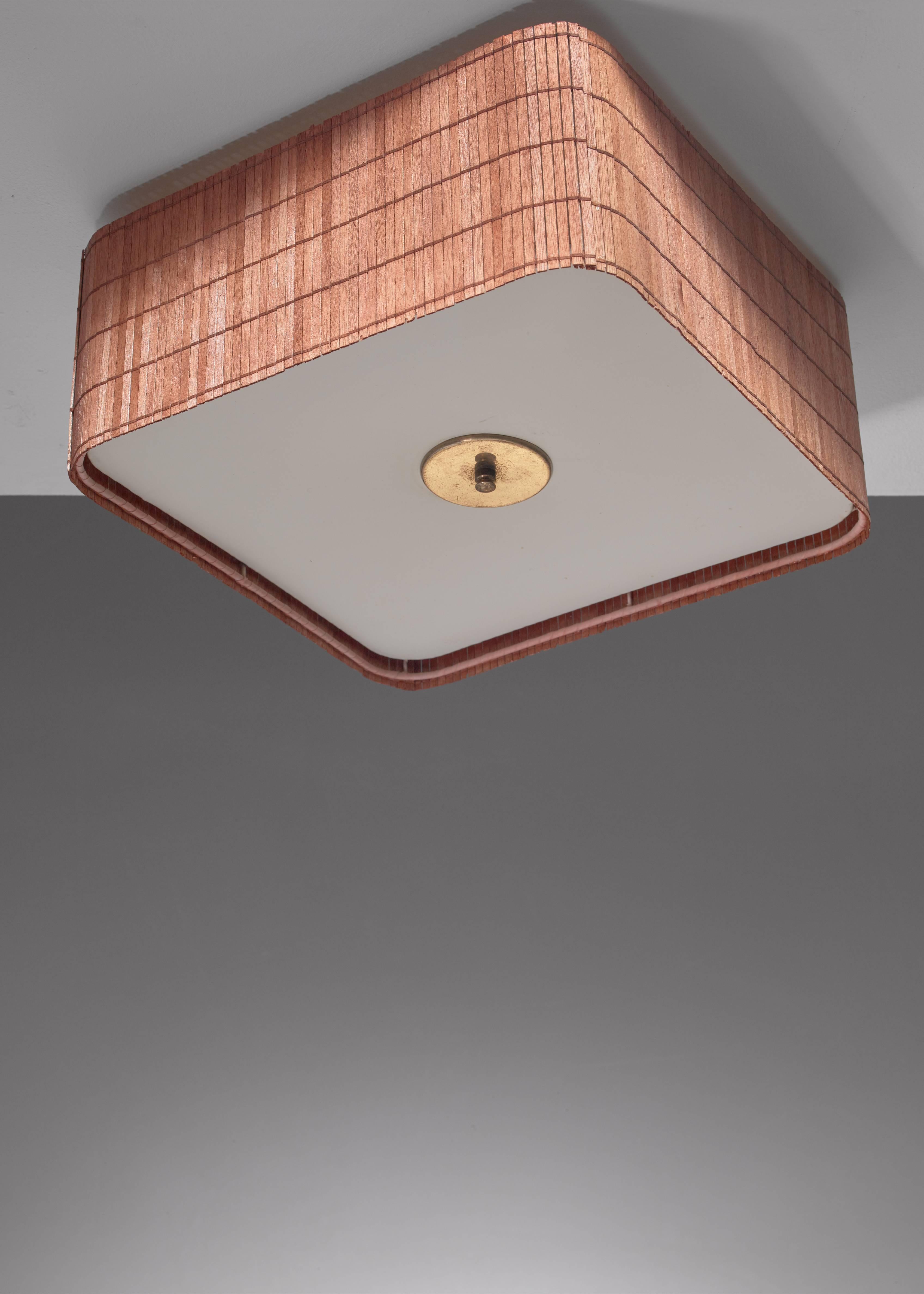 A rare Paavo Tynell square flush mount ceiling lamp for Taito, from circa 1950. The lamp is made of thin wood strips woven together and a plastic fabric diffuser.
*This piece is curated for you by Bloomberry *