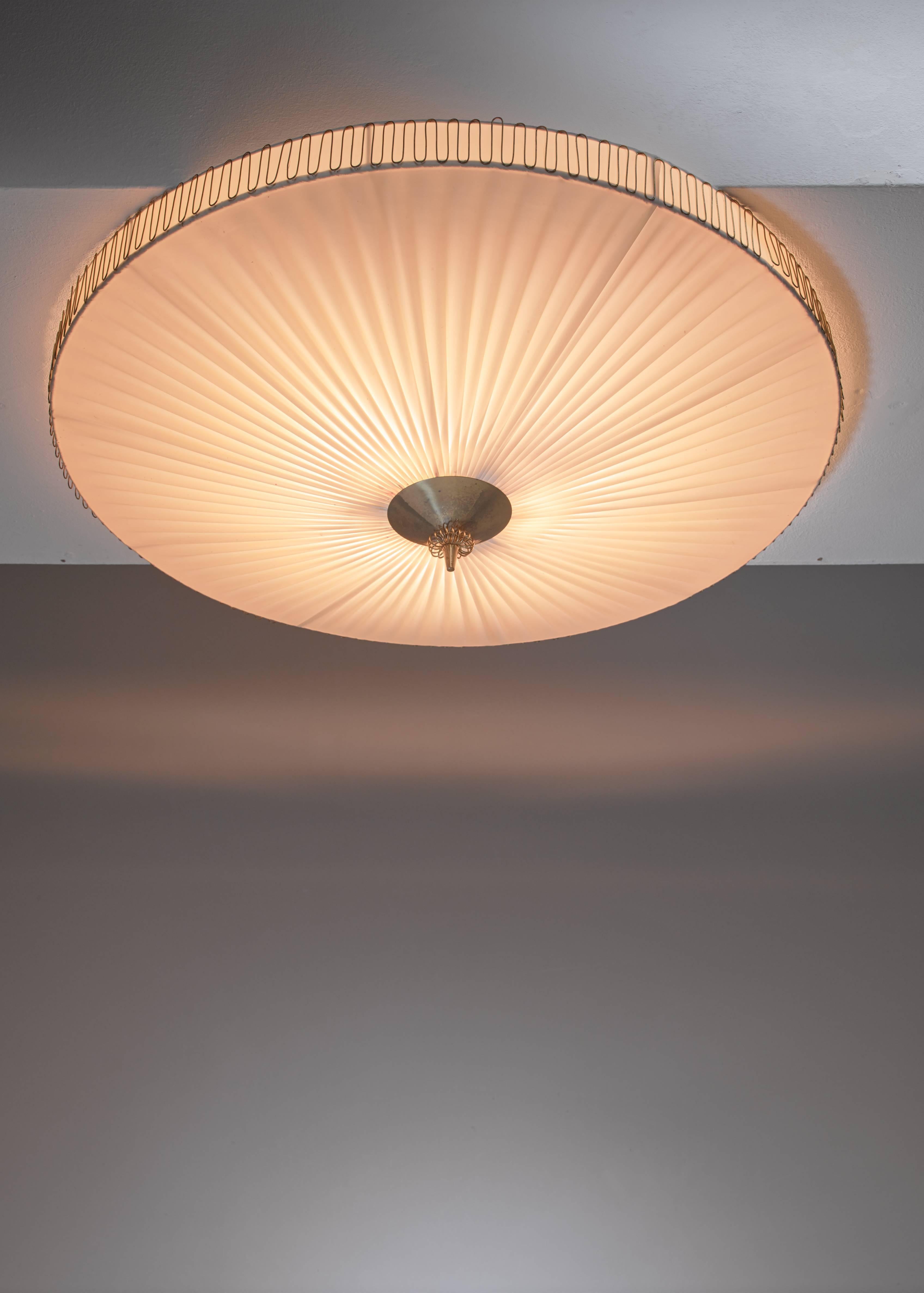 A large (75 cm diameter) round pleated flush mount ceiling lamp with a brass centre by Idman. The lamp has three light bulbs inside and is marked.

*This piece is curated for you by Bloomberry *