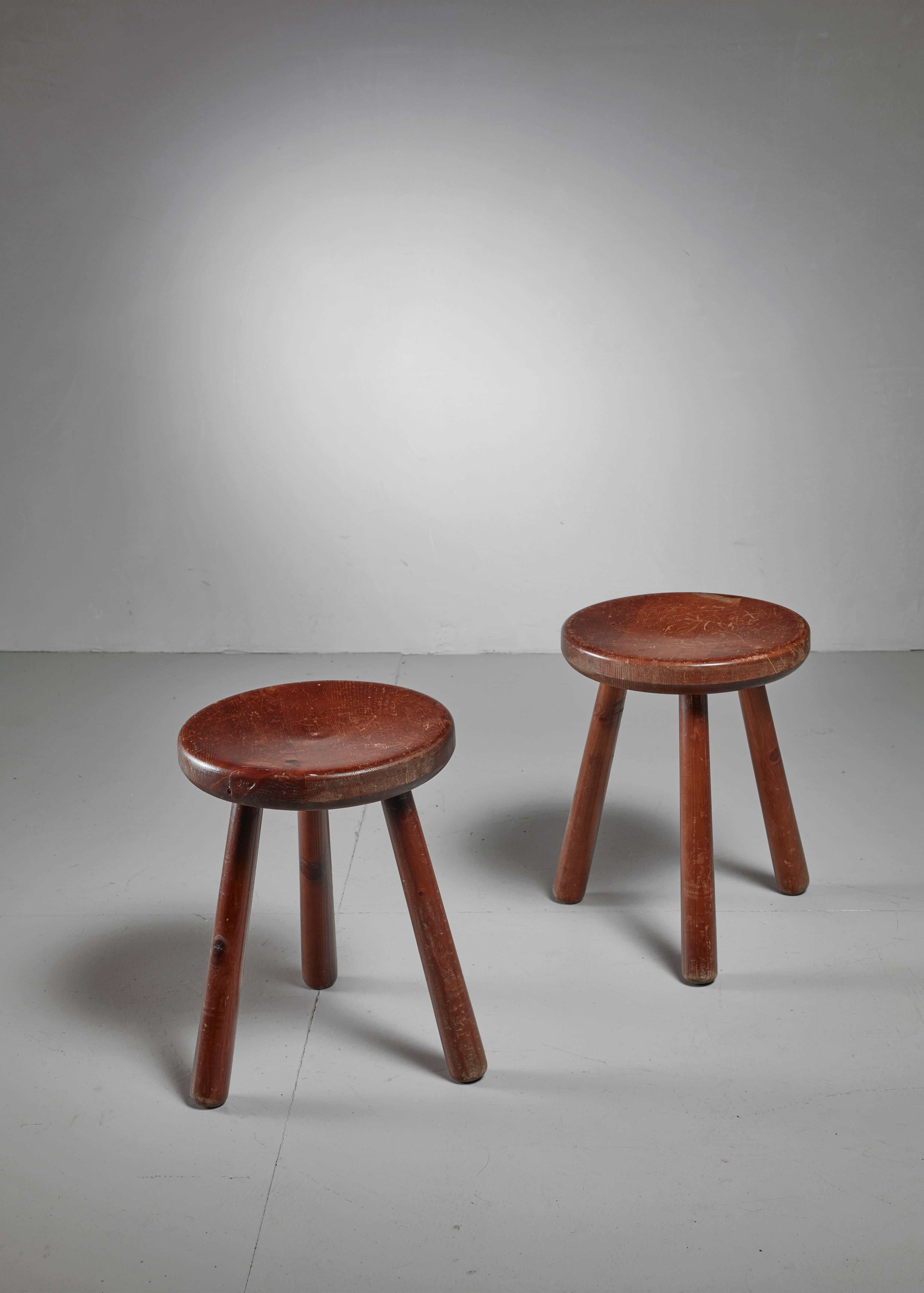 A pair of French Campagne style tripod stools, in the manner of Charlotte Perriand. They have a round (35 cm diameter) and slightly concave seating.

  