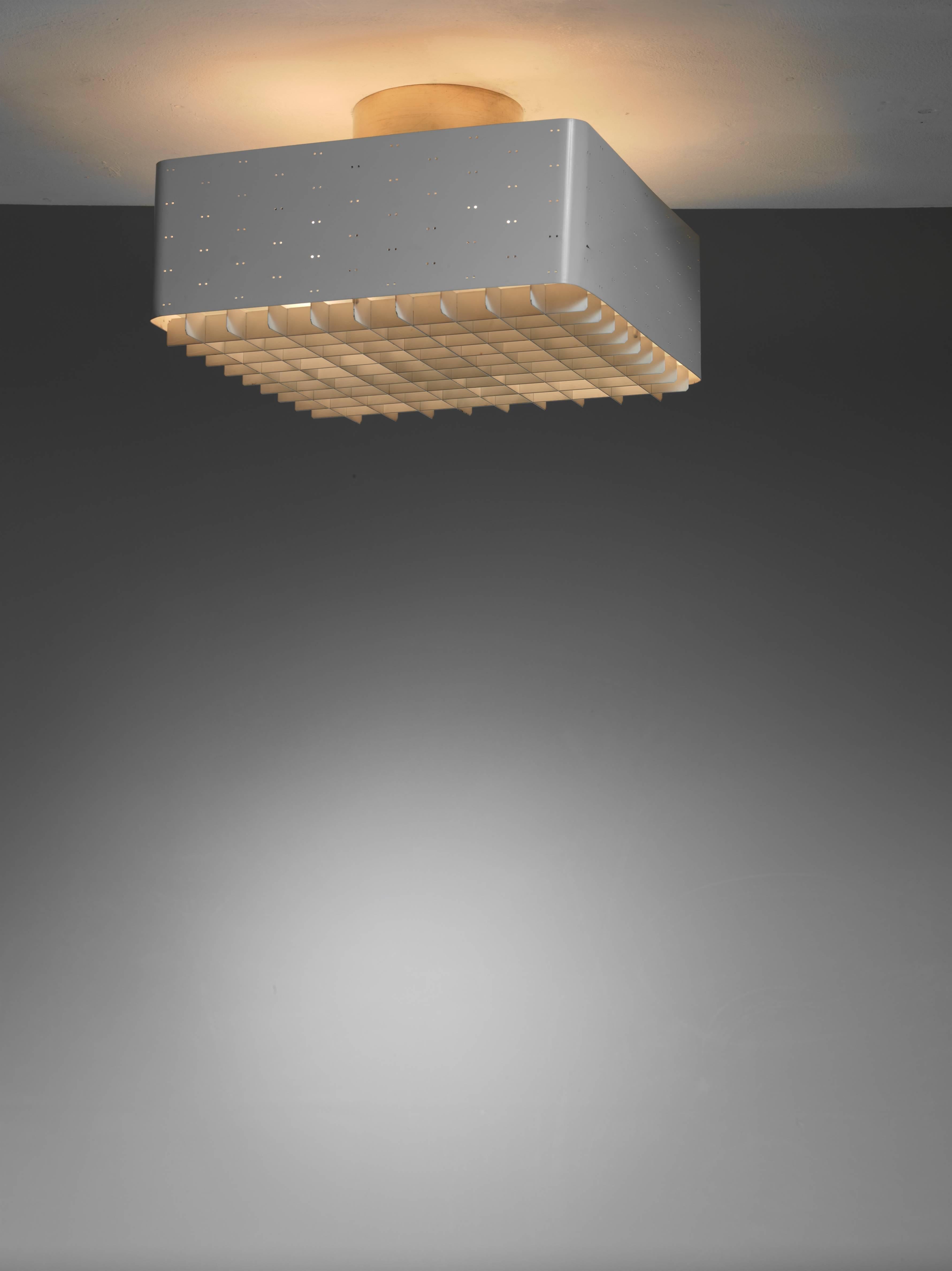 A white lacquered model 9068 Paavo Tynell ceiling lamp for Idman. This flush mount has twin dot perforations and a frosted glass diffuser for a beautiful light distribution. The brass ceiling cap and white grid make it very enigmatic. We have