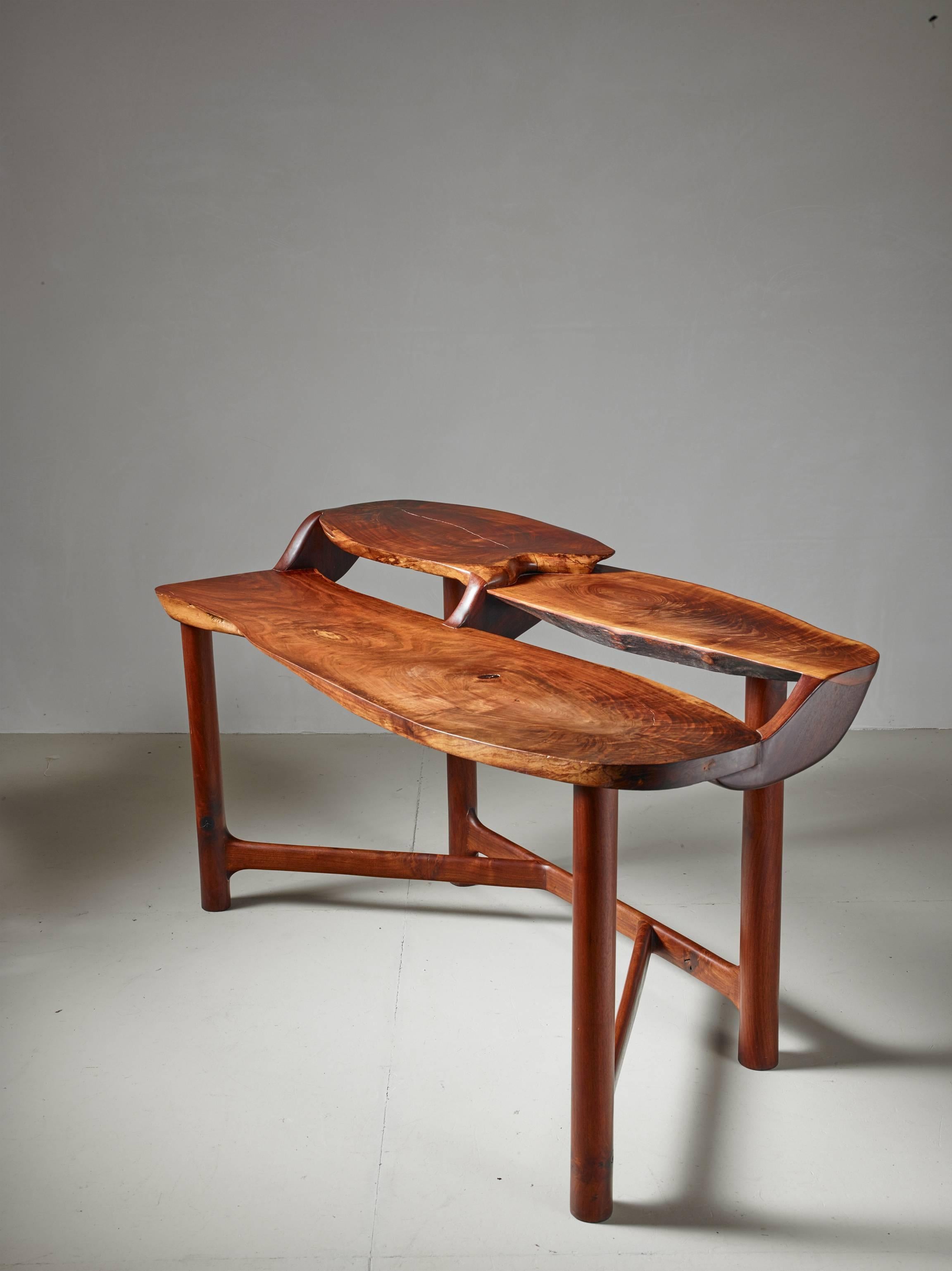 A studio crafted and sculptural wooden desk in walnut by American woodworker Ejner Pagh. The desk has a level for writing and two higher levels for storage. The desk is signed by Pagh.
This piece was bought directly from Ejnar Pagh and was made in