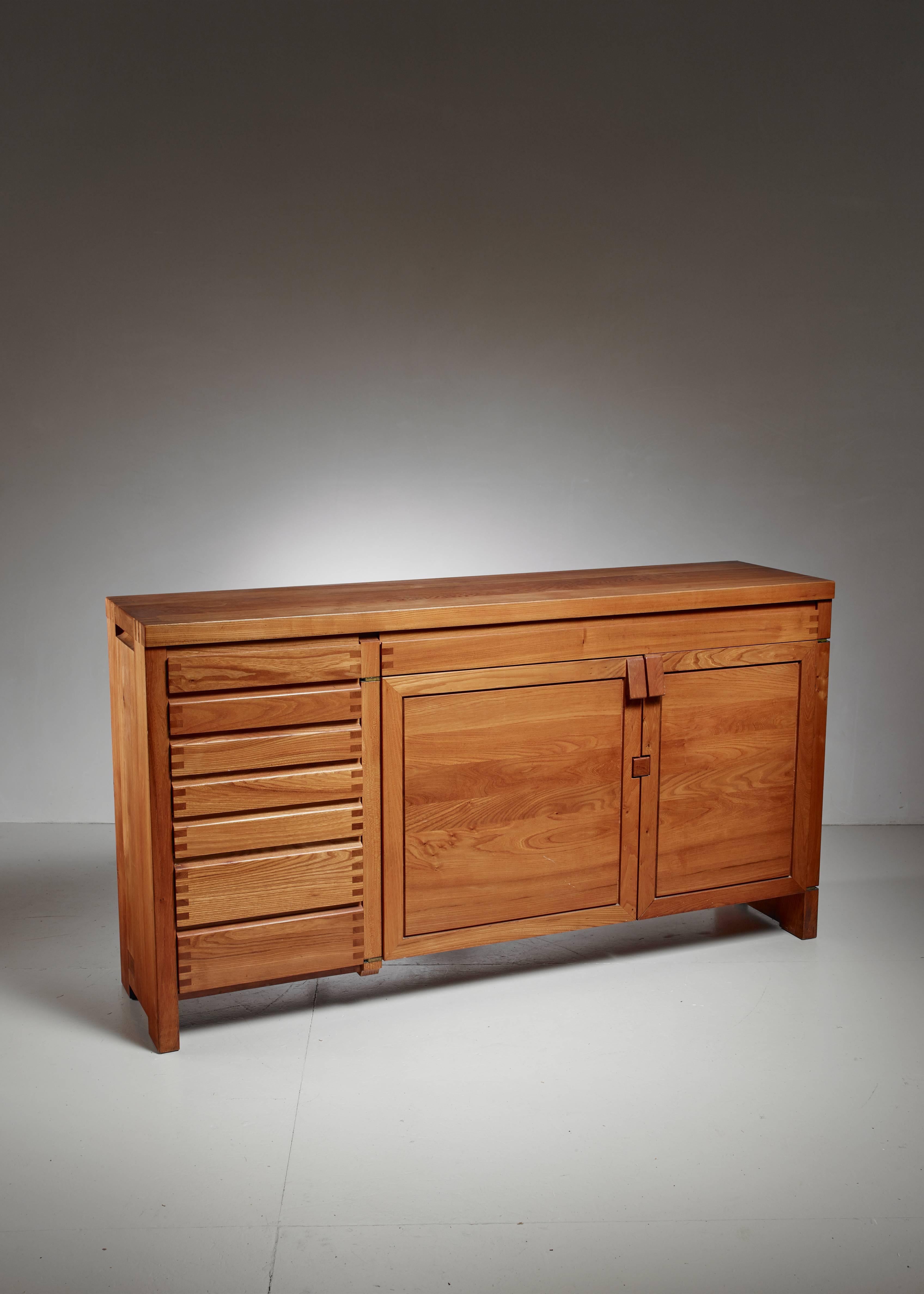 A large custom-made Pierre Chapo model R13 freestanding sideboard. This sideboard has two doors with triangle shaped knobs. The doors are locked by clamping them on the wooden block between them. There are seven smaller drawers and one large drawer