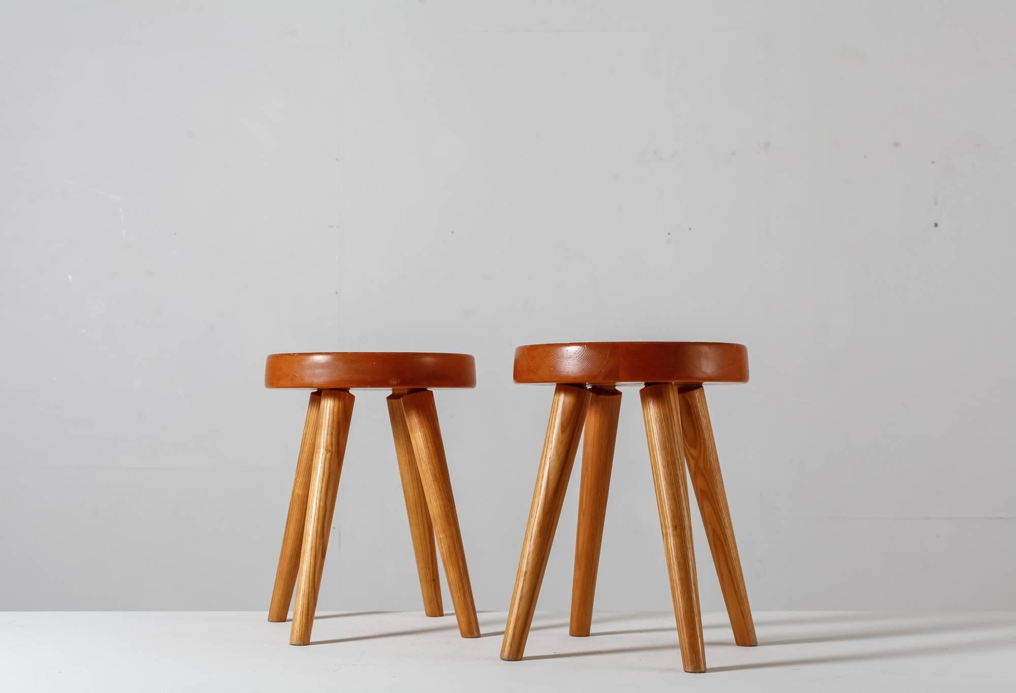 A pair of Charlotte Perriand four-legged stools made of pine. These stools were produced by Steph Simon.