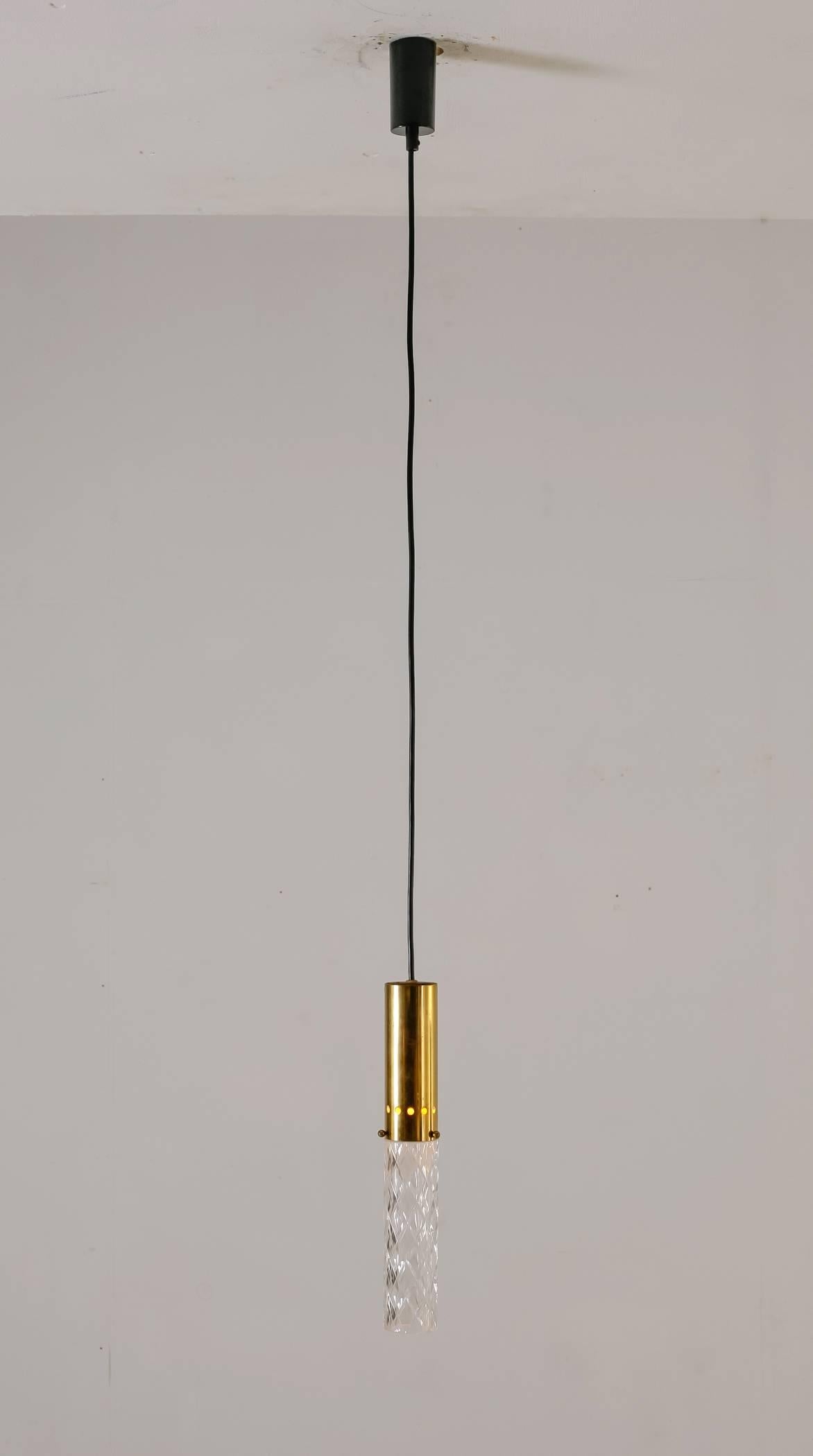 A set of three  thin, cylindricalpendant lamp from Italy, made of a brass base with a crystal diffuser attached to it. A minimalist yet elegant design.