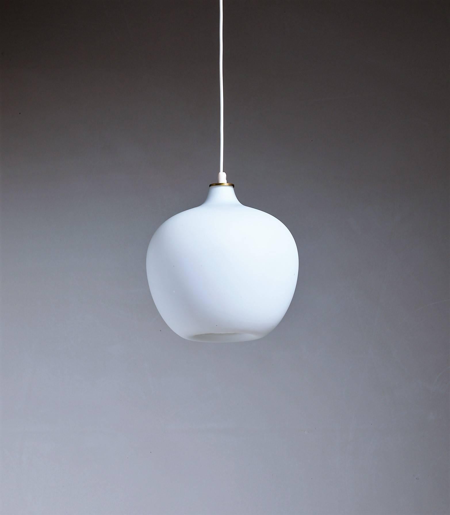 A Tapio Wirkkala model 51129 pendant for Idman, made of an opaline glass inward curved diffuser, a brass ceiling mount and a beautiful brass ring at the top. Just the little detail that makes the difference.
Total drop can be adjusted to your