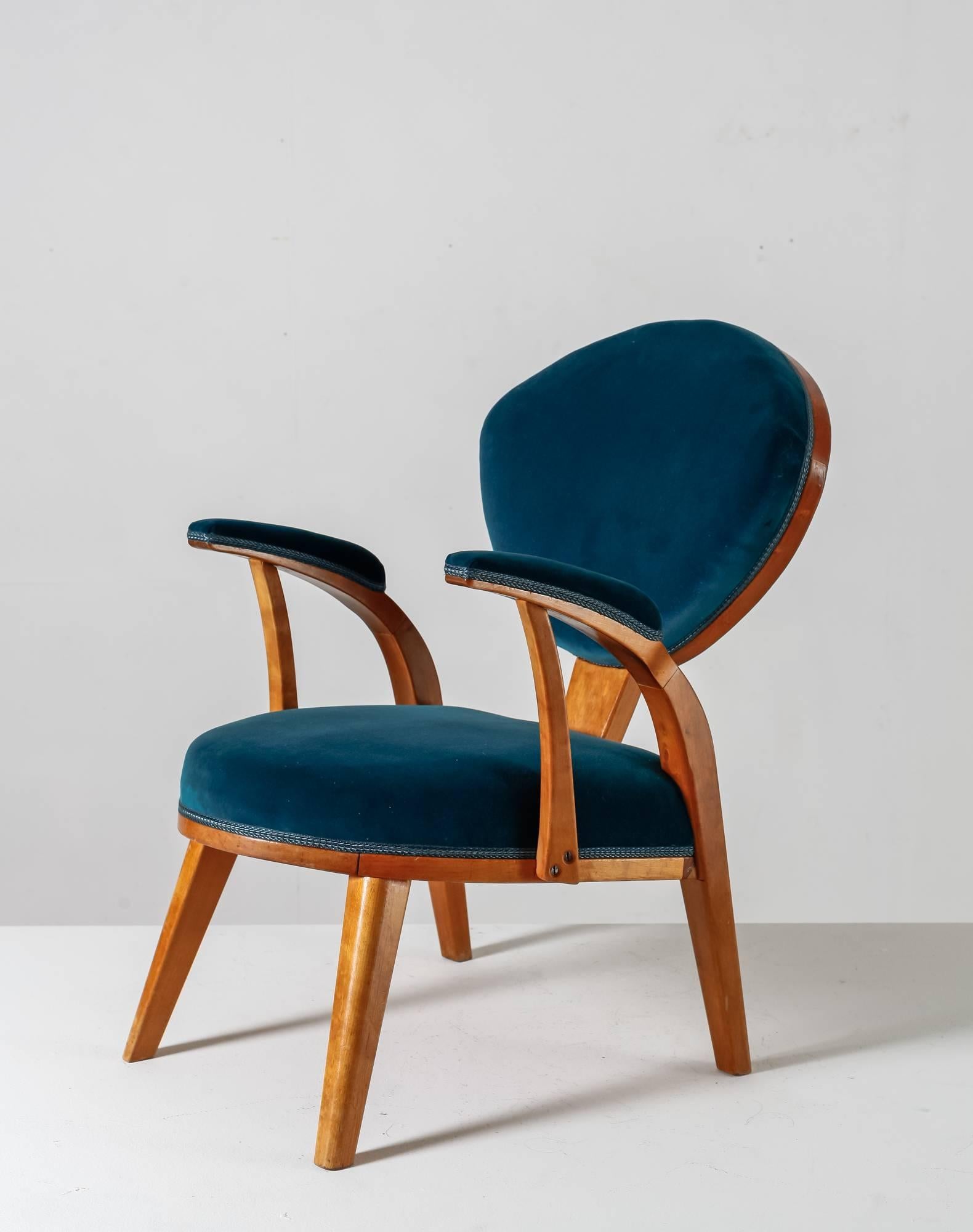 An armchair from Sweden, made of a beech frame and upholstered with a jade green velvet upholstery.
The seating tilts back slightly and the armrests have a lovely curve and a velvet upholstery on top. Beautiful wood construction on the back.