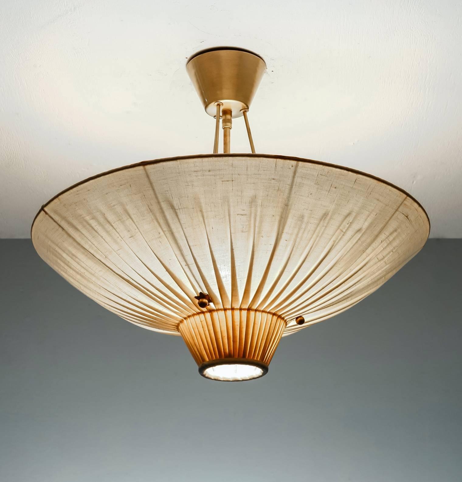 A 1940s pendant by Hans Bergström for Ateljé Lyktan. The lamp is made of a brass ceiling mount and a pleated off-white silk shade, which is fixed with three brass flower-like elements. The silk shade creates a stunning light distribution.
Labeled