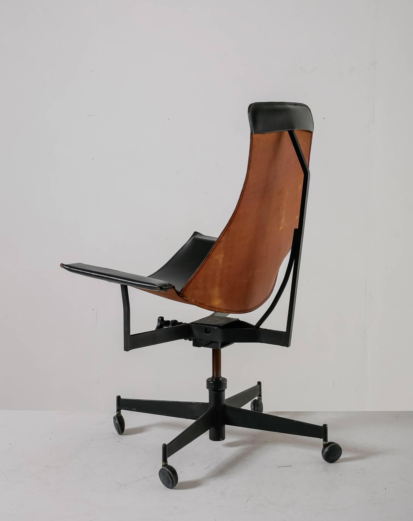 A swiveling and height-adjustable chair with a black and brown leather sling seat in a metal frame, by American architect and designer William Katavolos. With its wheels, it is a perfect office chair, but can also be used as a lounge chair.
This