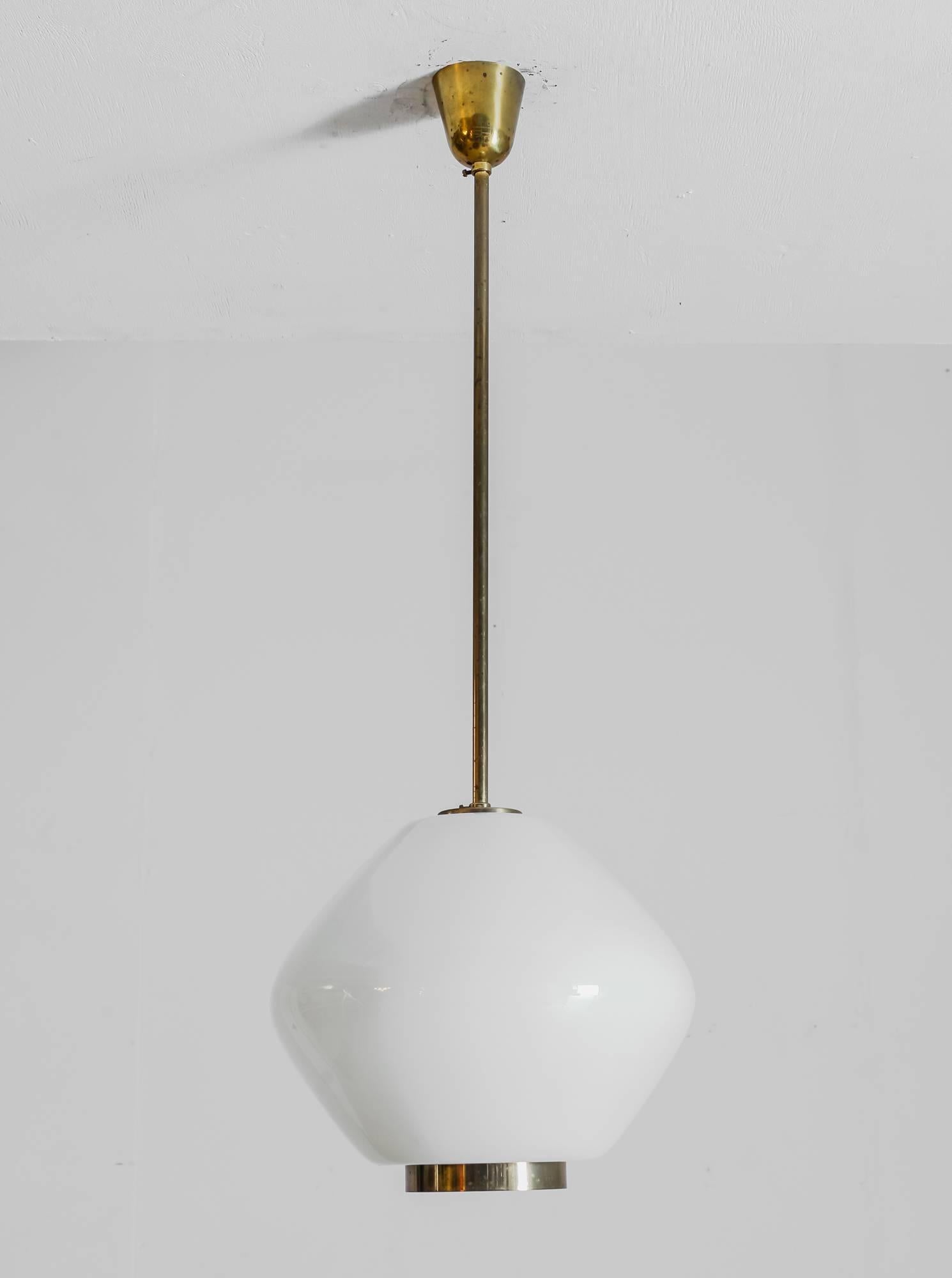 A rare Paavo Tynell pendant made of opaline glass for Idman. The lamp has a brass stem and a brass ring around the opening underneath.
This lamp is marked by Idman and in a very good condition. The brass has a lovely patina.