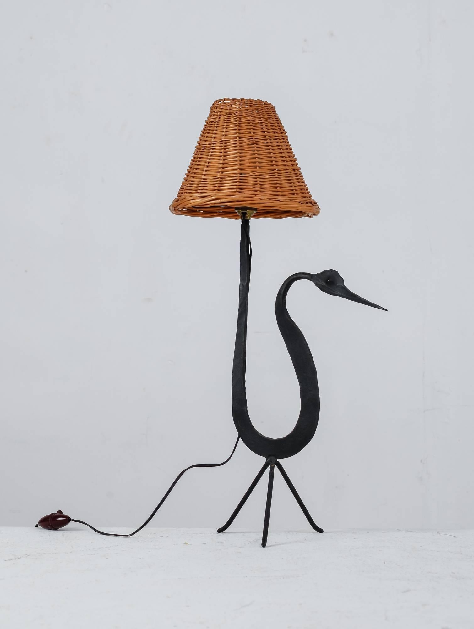 A small table lamp by Jean Touret for Atelier Marolles.
The lamp is made of a sculptural, bird-shaped iron frame with a wicker hood.

This piece was part of a large estate of Touret items, bought directly from the sons of the owners. The Atelier