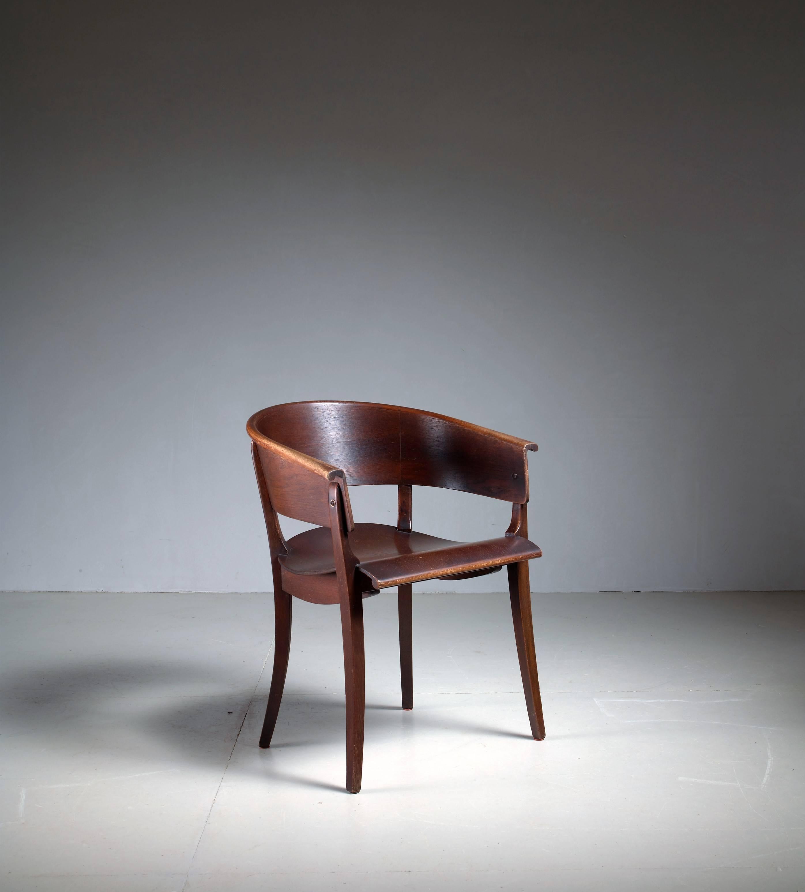 A curved armchair designed around 1928 by Ernst Rockhausen for Rockhausen, Germany.

The chair is made of beech plywood and oak veneer. Stamped by Rockhausen underneath. There are some minor losses to the veneer, but the chair is in an overall very