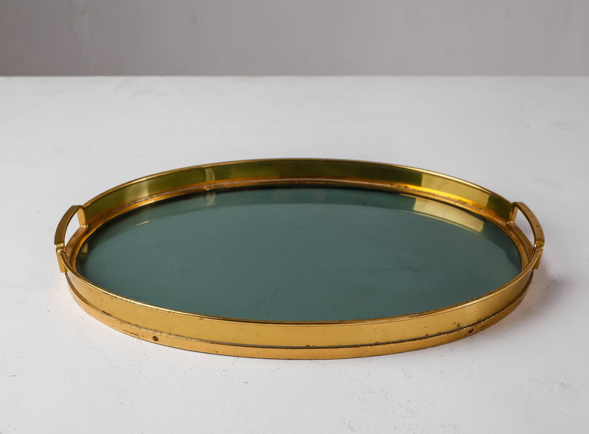 An Italian serving tray, made of an oval brass rim with grips and a smokey glass bottom. The brass has a beautiful patina and the tray is in a great condition.