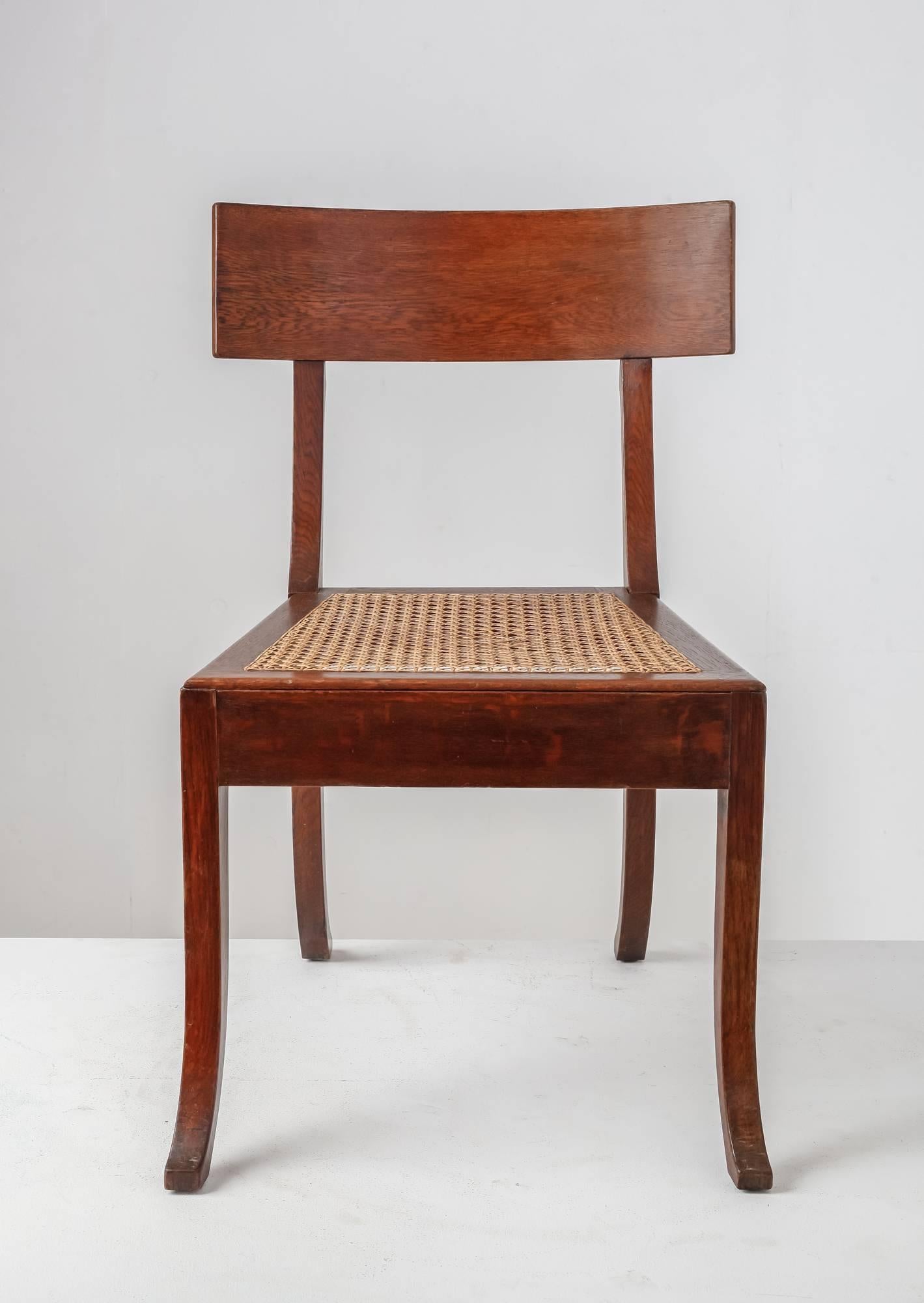 A large Klismos chair in oak by Danish architect Ole Peter Momme (1854-1899). It has a woven cane seating in an excellent condition. This chair was designed for The Roskilde city hall, built by Momme in 1883-1884. The design of the Klismos chair,