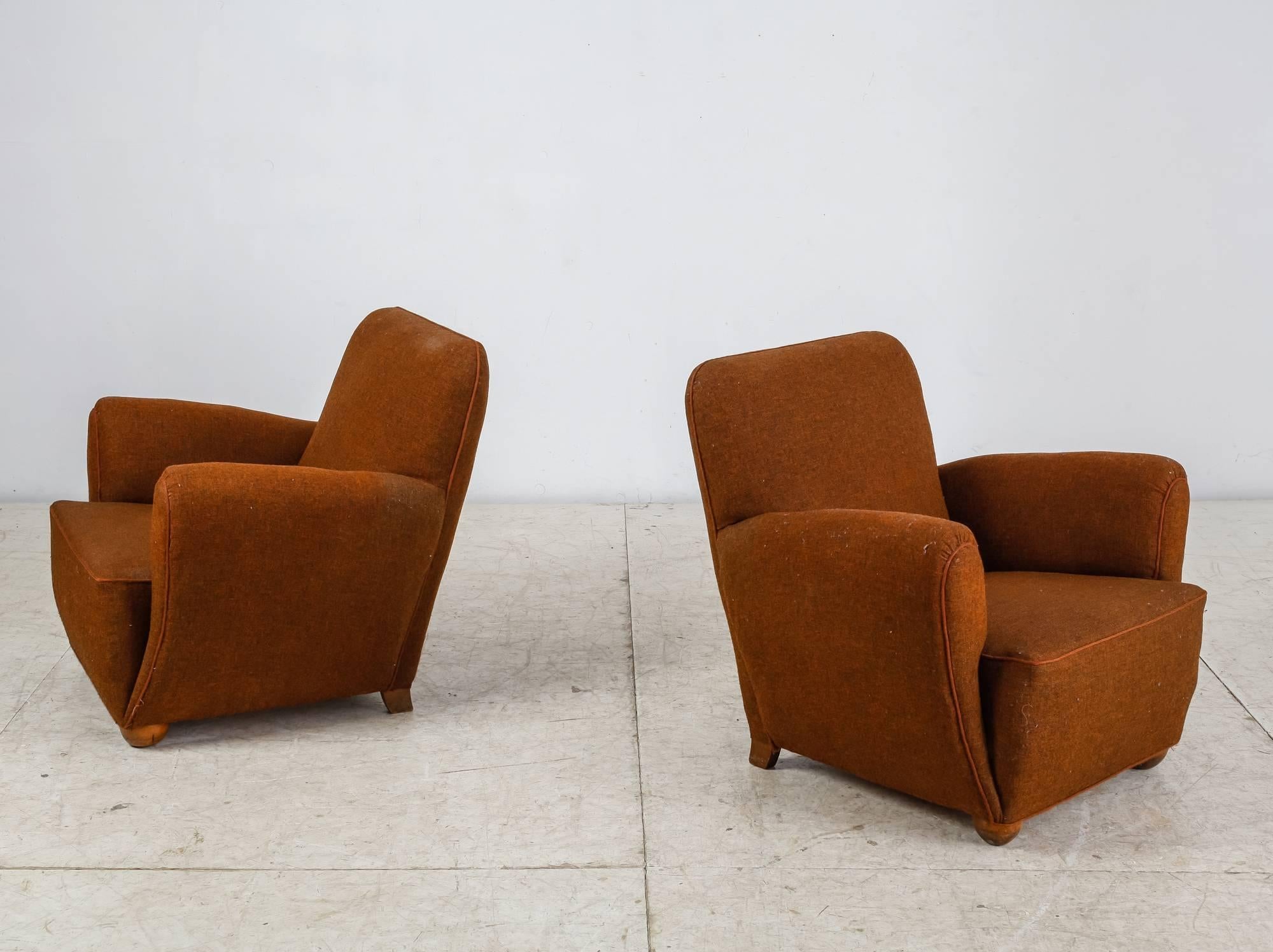 A pair of Danish 1940s lounge chairs with a brown wool upholstery and matching piping, standing on stained beech legs. These comfortable chairs have a beautiful round form.
We have a matching sofa available.