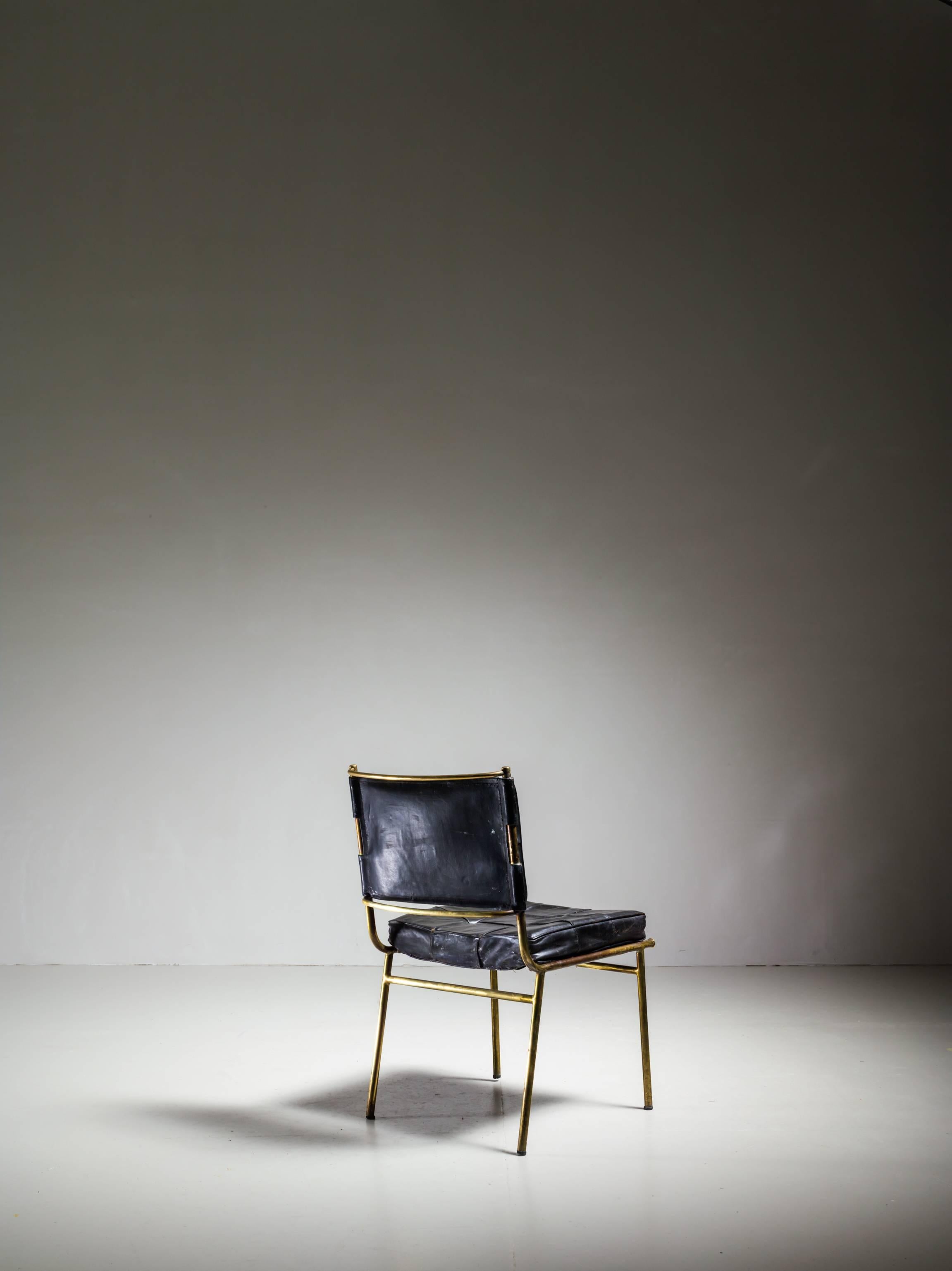 A rare and published Mathieu Matégot chair from the 1950s. The chair is made of a brass frame with a black padded leather cushion and backrest. The backrest tilts back slightly, for a comfortable seating position. At the top, the frame has a curved