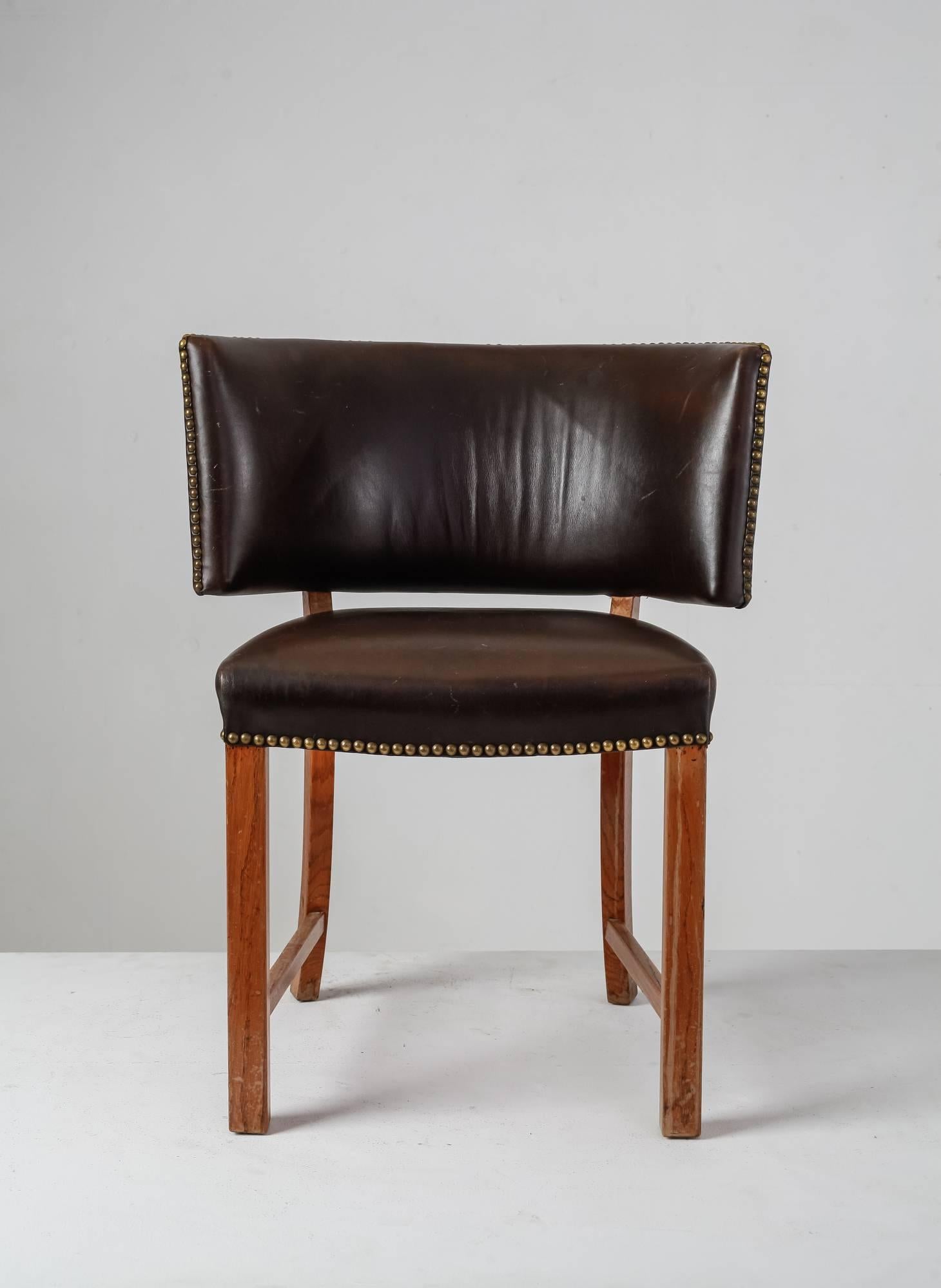 A 1930s Danish sidechair with a large, curved backrest. The chair stands on oak legs and is upholstered with studded dark brown leather.The wide backrest and slightly curved back legs are inspired by the Classic Klismos chairs.A remarkable chair in