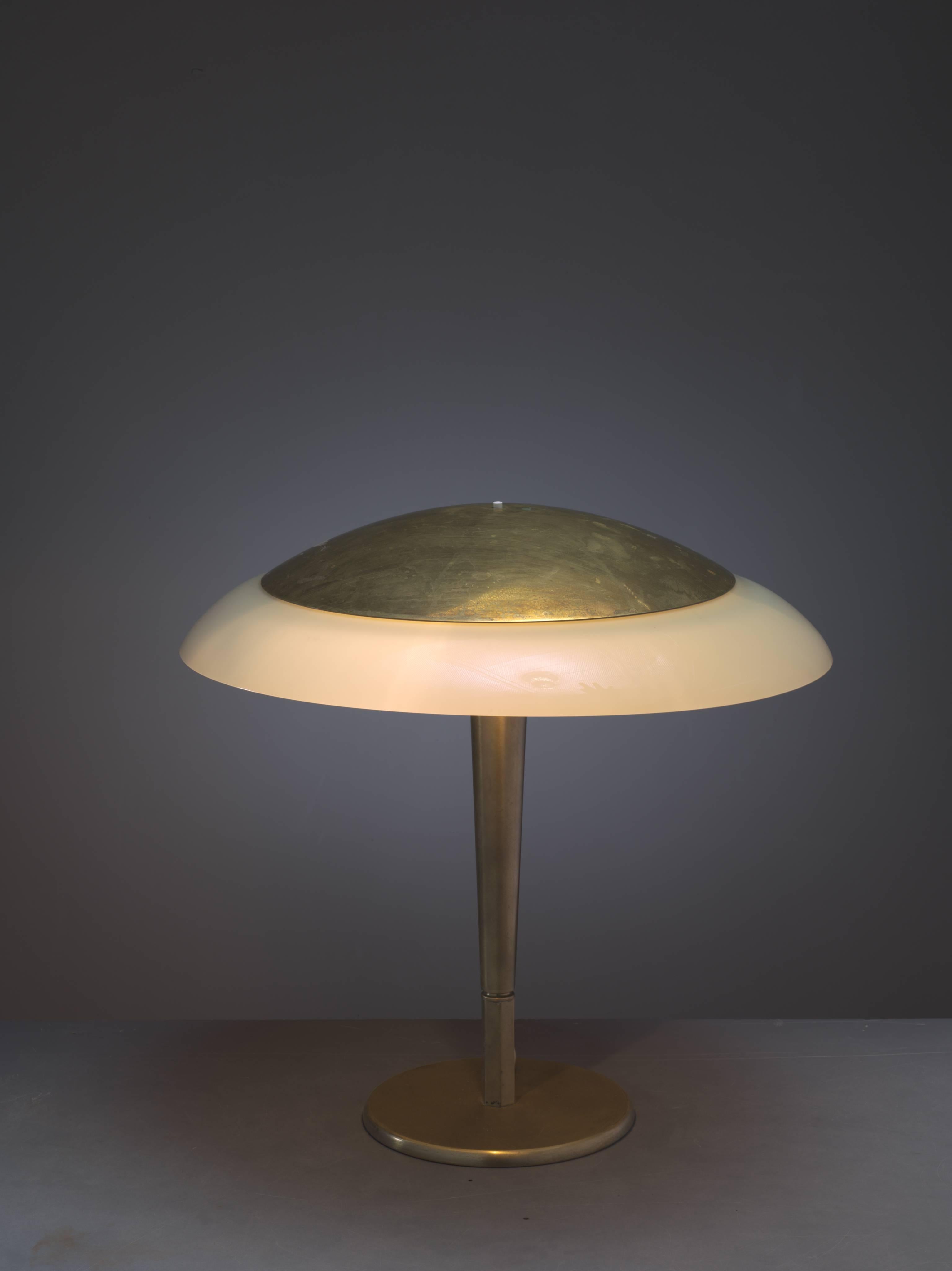 A rare and early model 5061 table lamp by Paavo Tynell, visibly marked with 'Taito' and the model number.
The lamp is made of a heavy brass base and stem with an opaline glass shade, with a smaller brass cap on top.