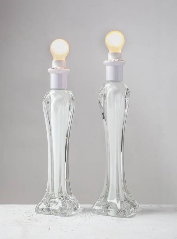 A pair of table lamps made of sculptural clear glass with a white glass core, by Swedish company Flygsfors. The lamps are slightly different in height: one is 45 cm (17.7 inch) high
and the other is 42.5 cm (16.7 inch) high.
Engraved with