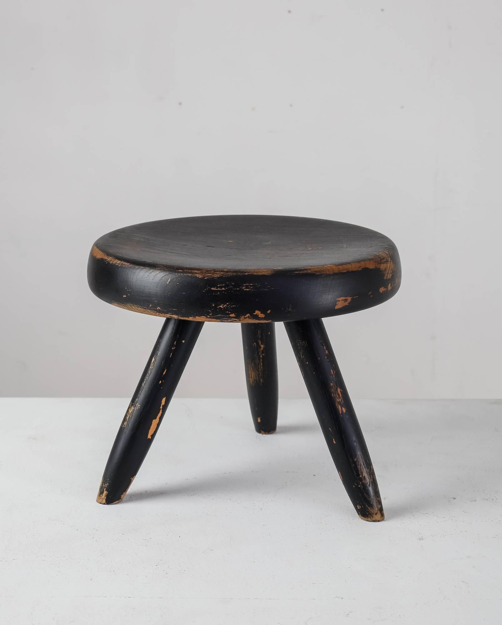 A low tripod stool in ebonized ash by Charlotte Perriand, with a great and strong patina.

The first tripod stool of this type by Perriand was designed in 1947 and produced by Georges Blanchon’s Bureau Central de Construction. In 1956 Perriand