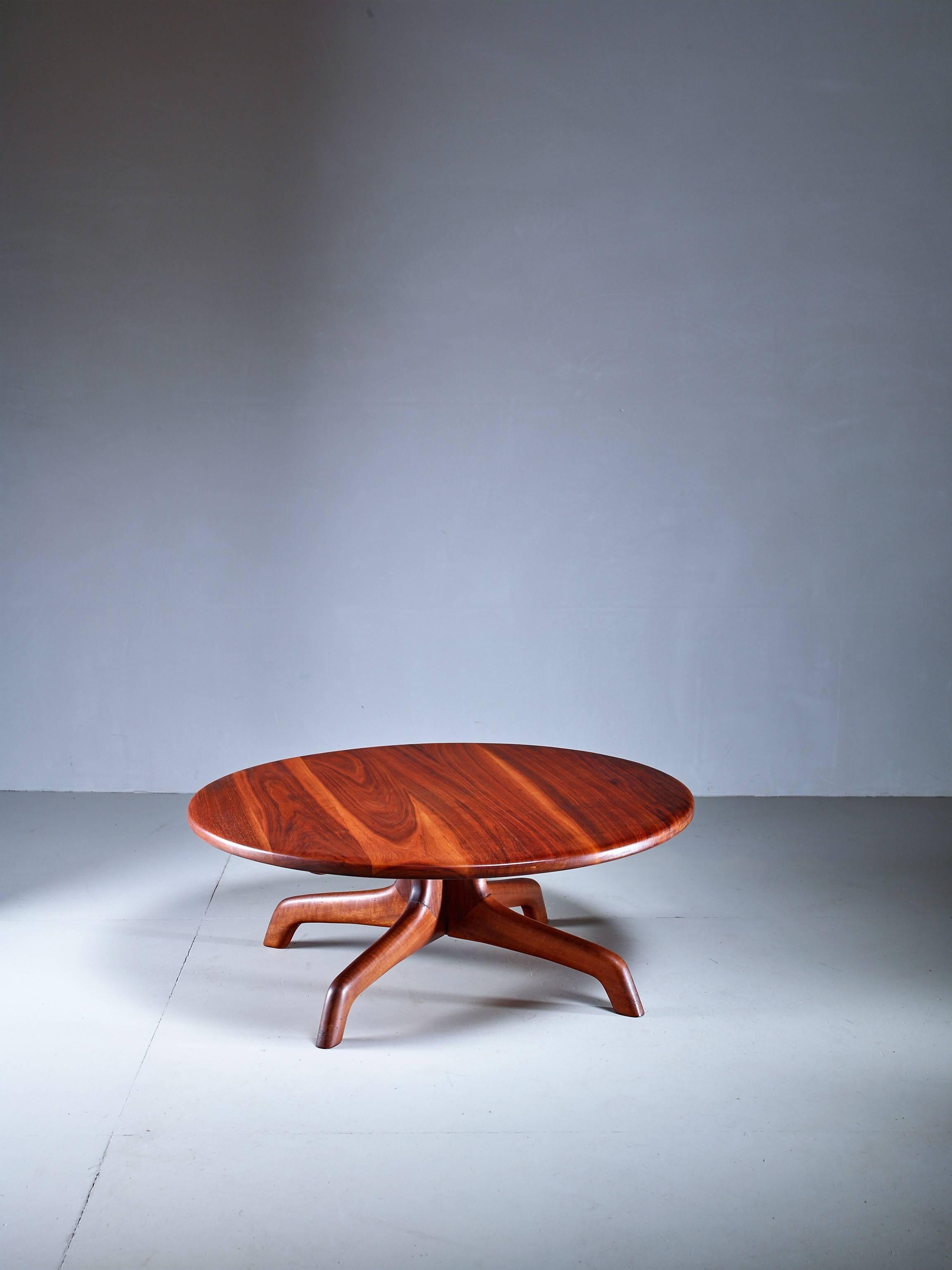 A round walnut coffee table with four wide feet attributed to American craftsman Arthur Espenet.

Born in New York City in 1920, Arthur Espenet Carpenter earned a degree in economics from Dartmouth College, then served four years in the Navy during